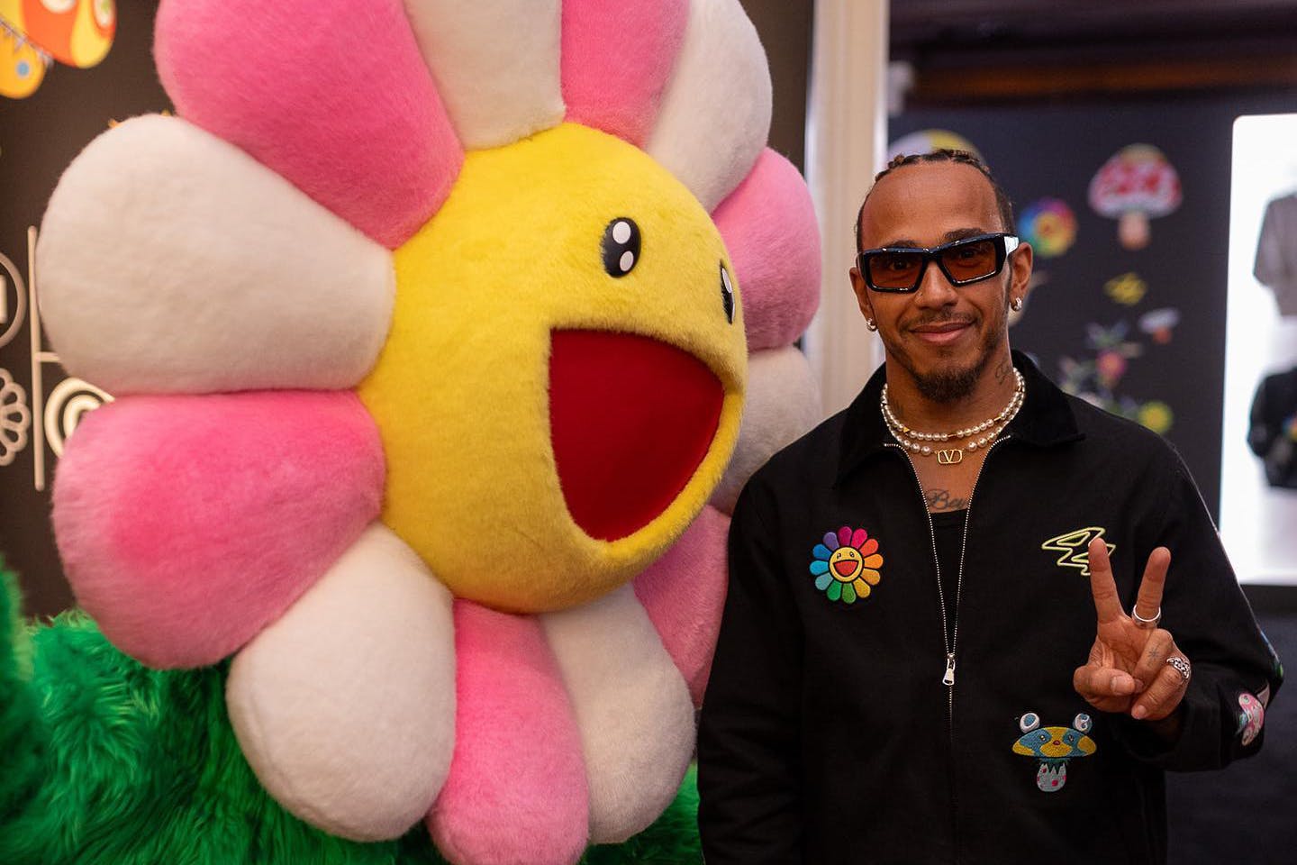 Lewis Hamilton posing with Takashi Murakami's flowers