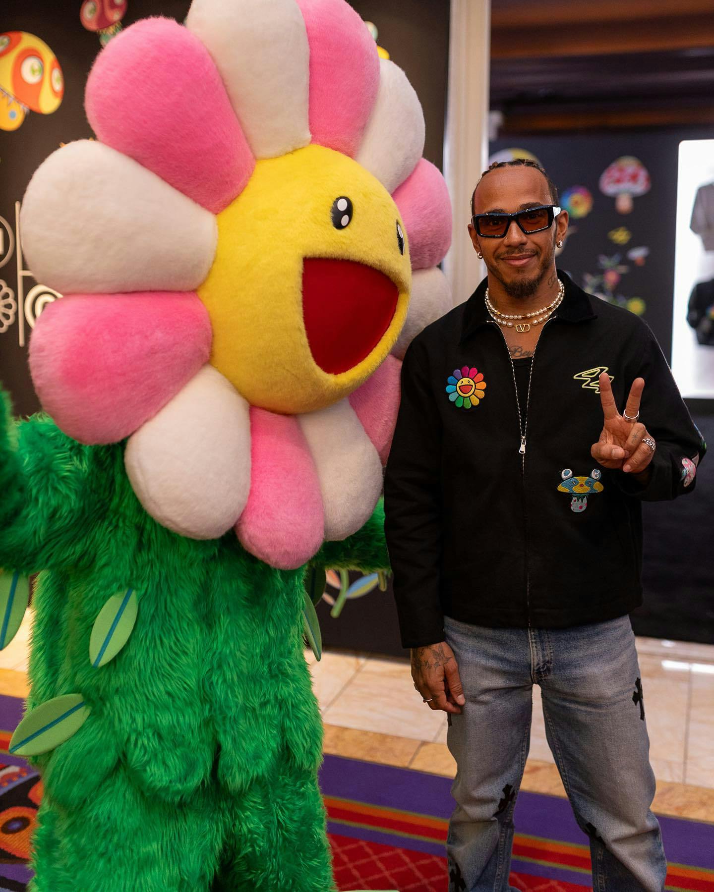 Lewis Hamilton posing with Takashi Murakami's flowers