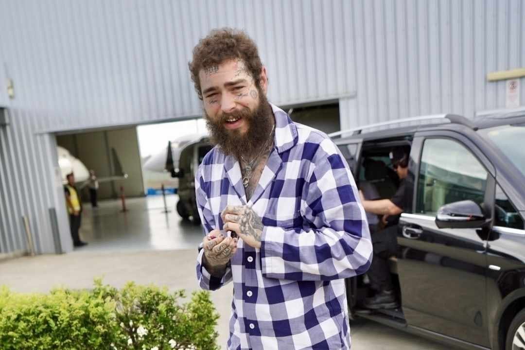 Post Malone wears plaid pajamas & camouflage crocs in Australia