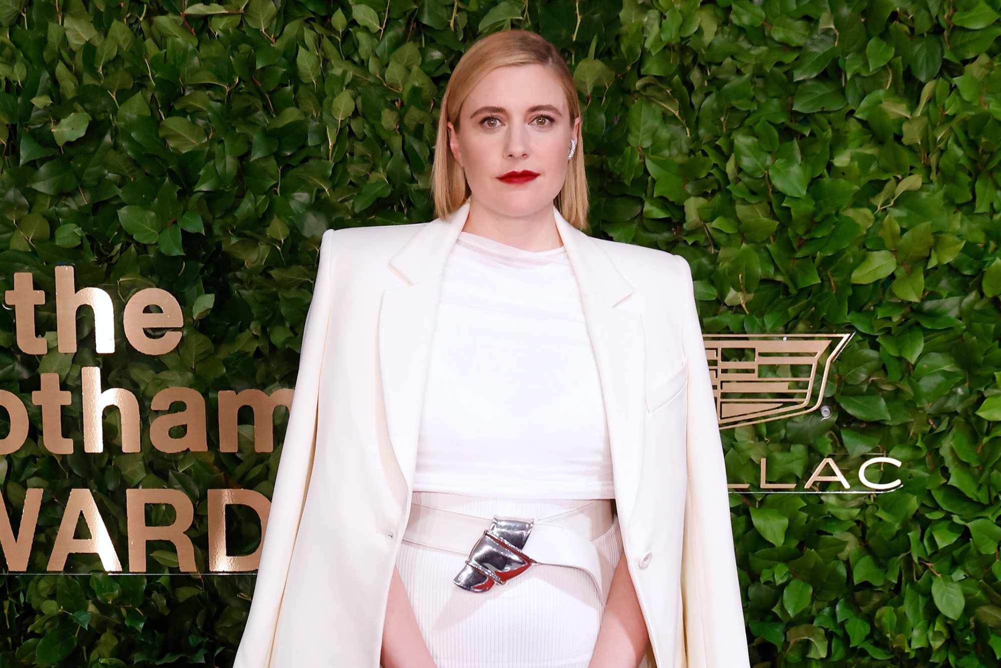 Greta Gerwig's red carpet look at the 2023 Gotham Fashion Awards, including a white blazer, white shirt, silver belt, and white skirt