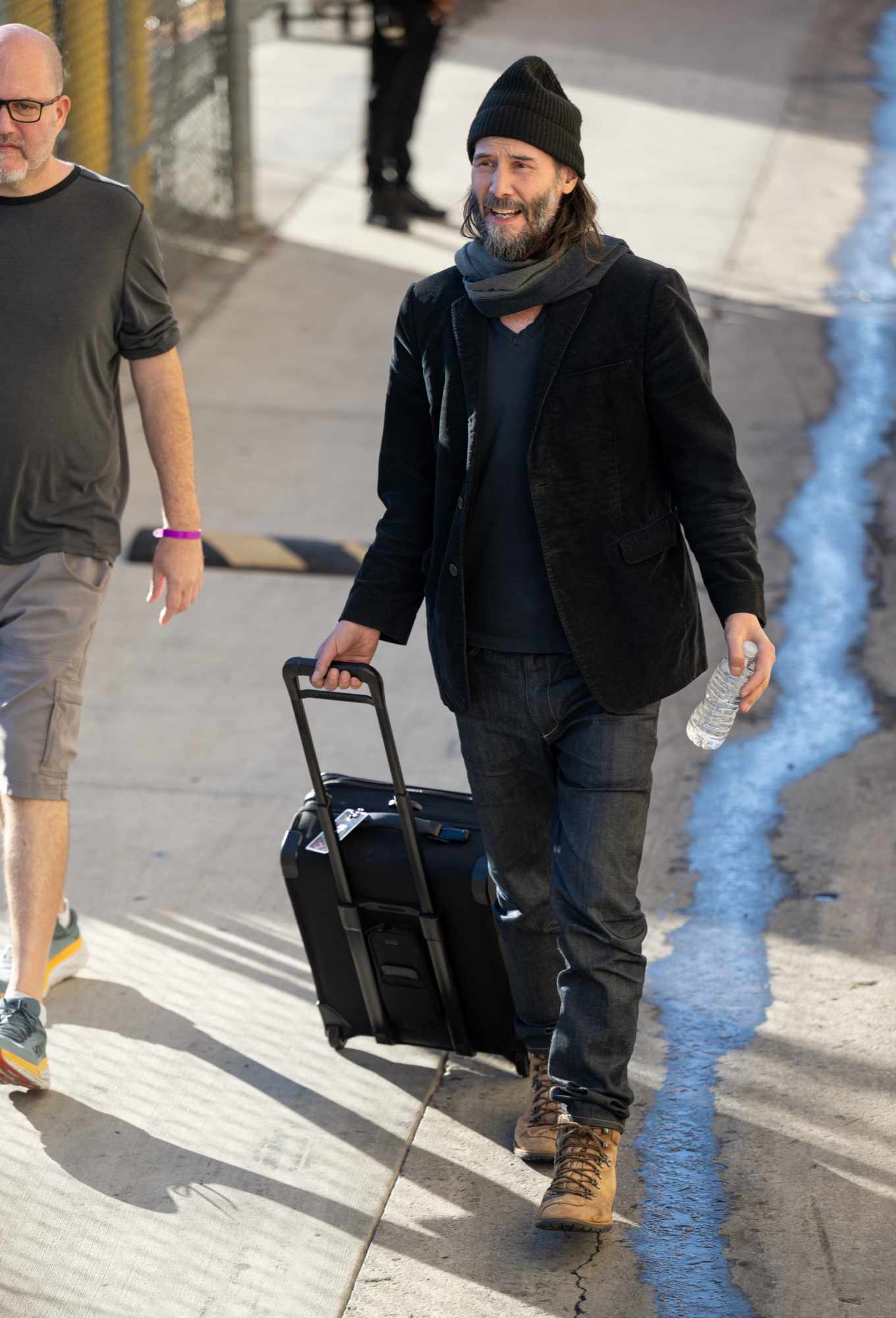 Keanu Reeves wears a beanie, brown blazer, sweater, jeans, and beige boots to perform on Kimmel with his band, Dogstar