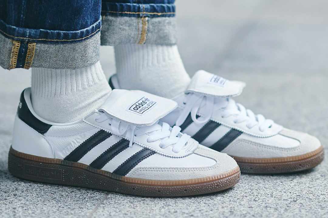 adidas' Handball Spezial sneakers in a white, black, and gum colorway with a folded over tongue