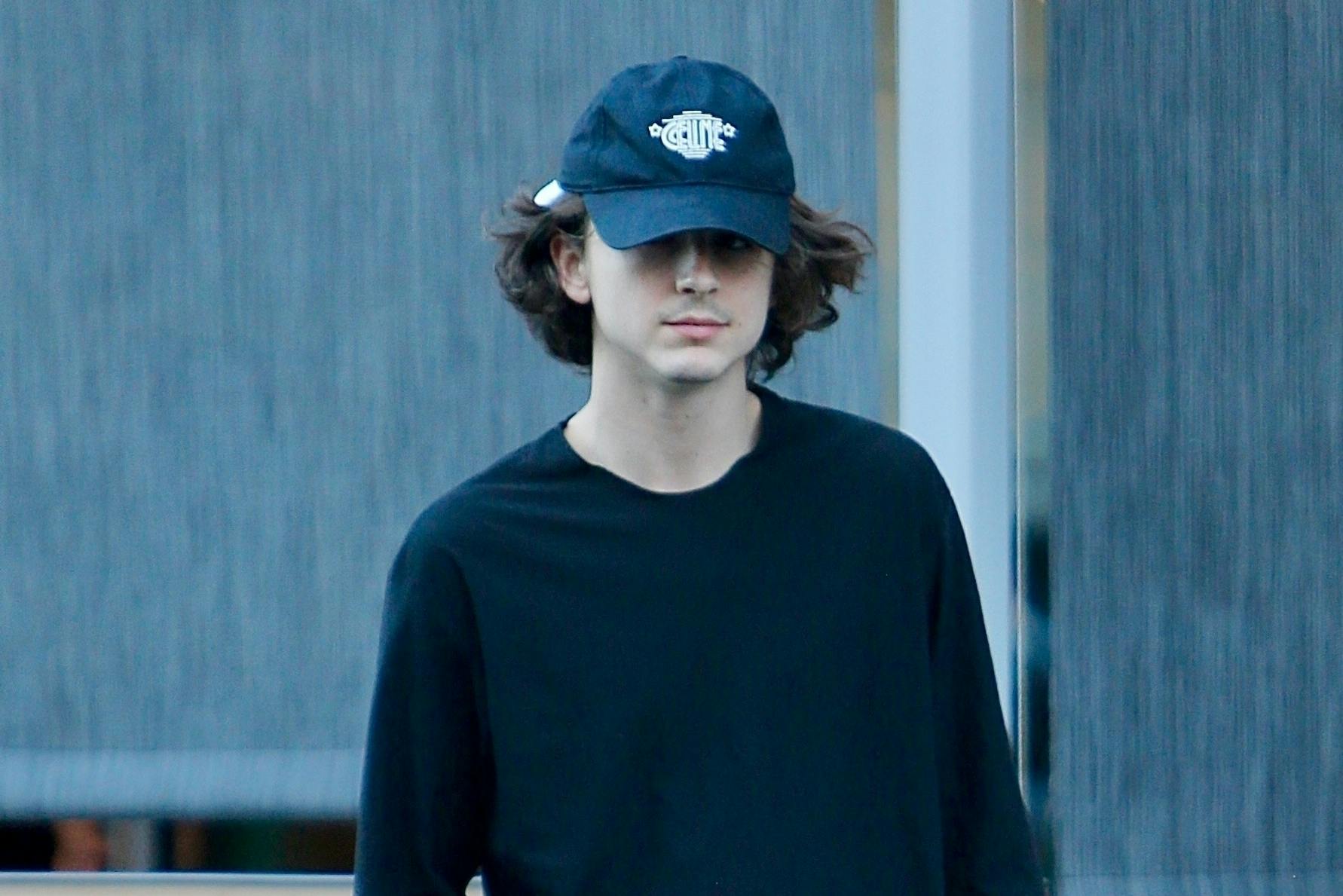 Timothée Chalamet in black sweats and a CELINE cap