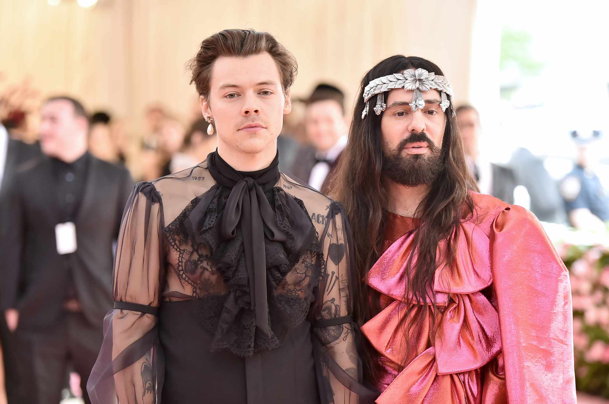 Harry Styles wearing a see-through black top stands next to Alessandro Michele, former Gucci creative director, wearing a red shirt, at the 2022 Met Gala