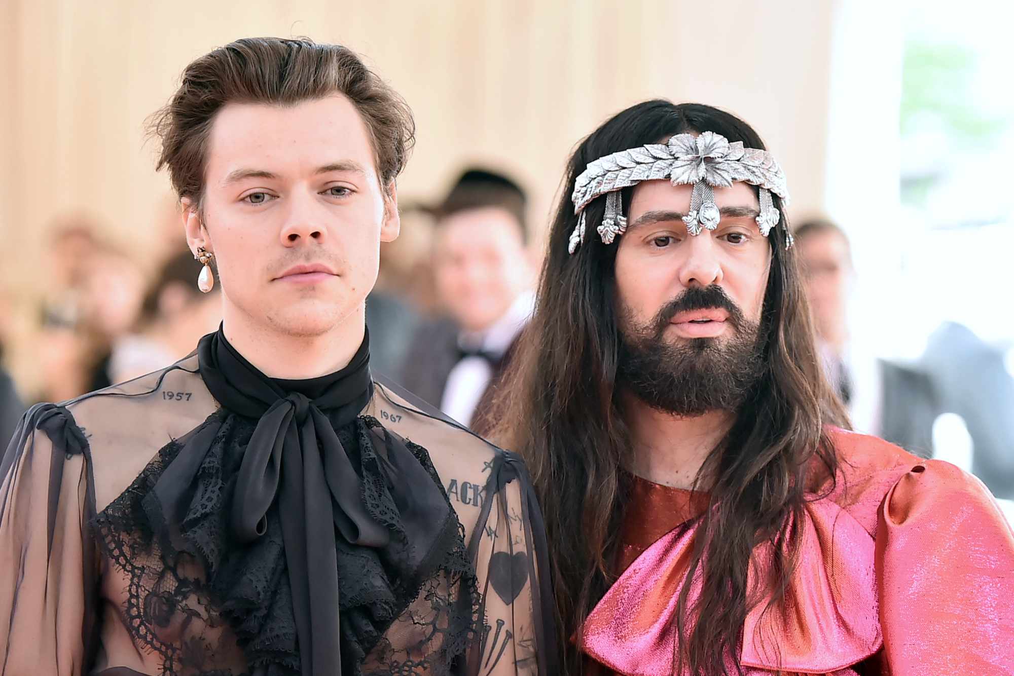 Harry Styles wearing a see-through black top stands next to Alessandro Michele, former Gucci creative director, wearing a red shirt, at the 2022 Met Gala