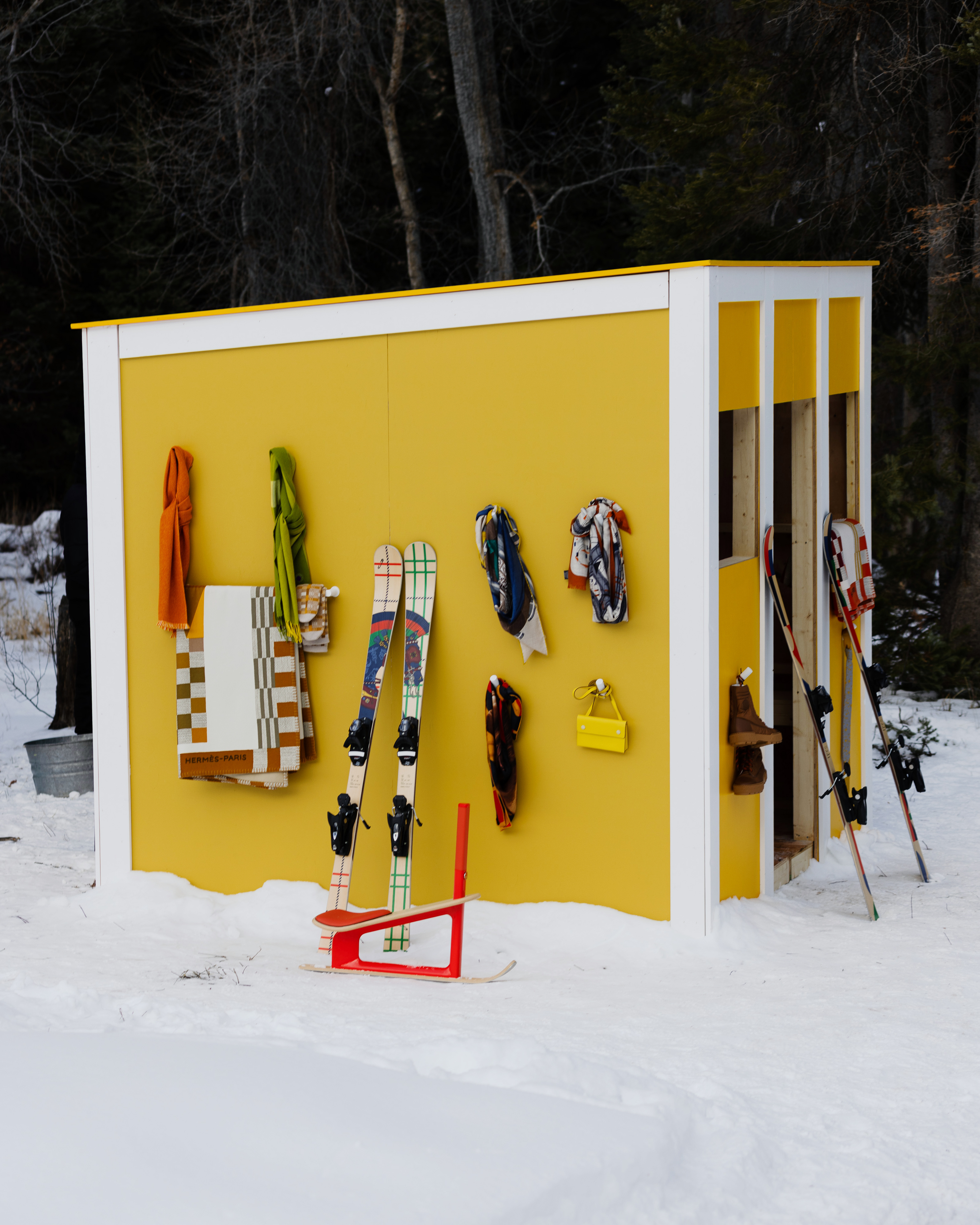 Yellow shed with ski gear captured at the Hermès Winter Camp