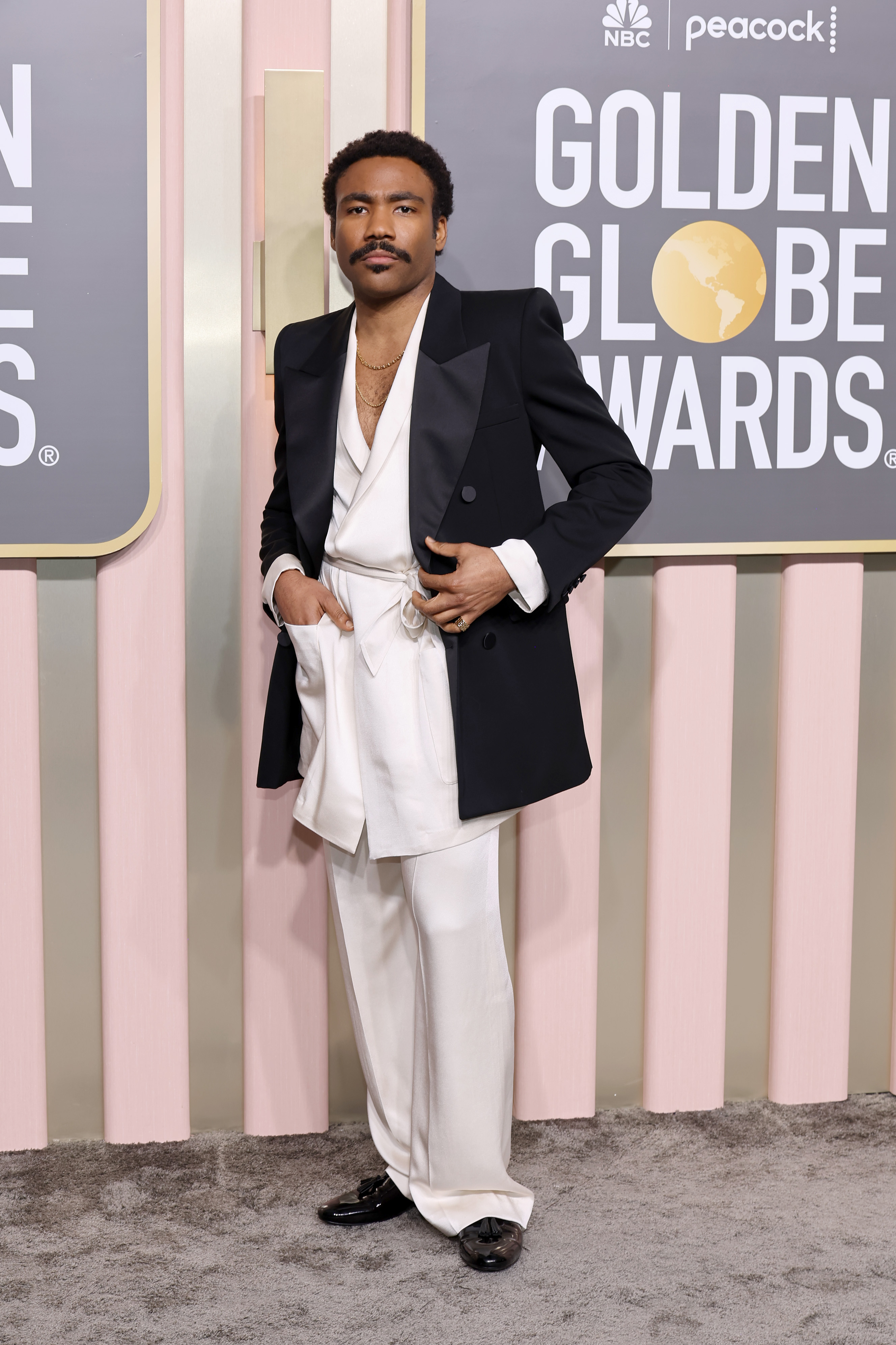 Donald Glover Wears a black jacket and white suit at the billboard awards