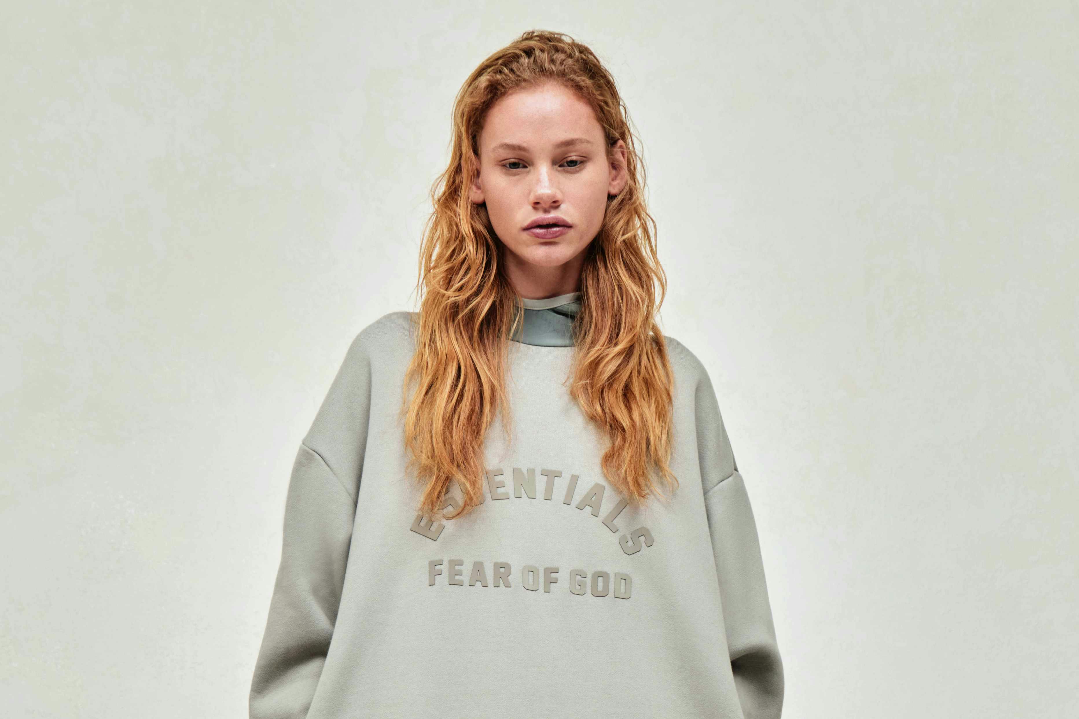 Models wear Fear of God ESSENTIALS' Winter 2023 hoodies, sweatshirts, t-shirts, and sweatpants