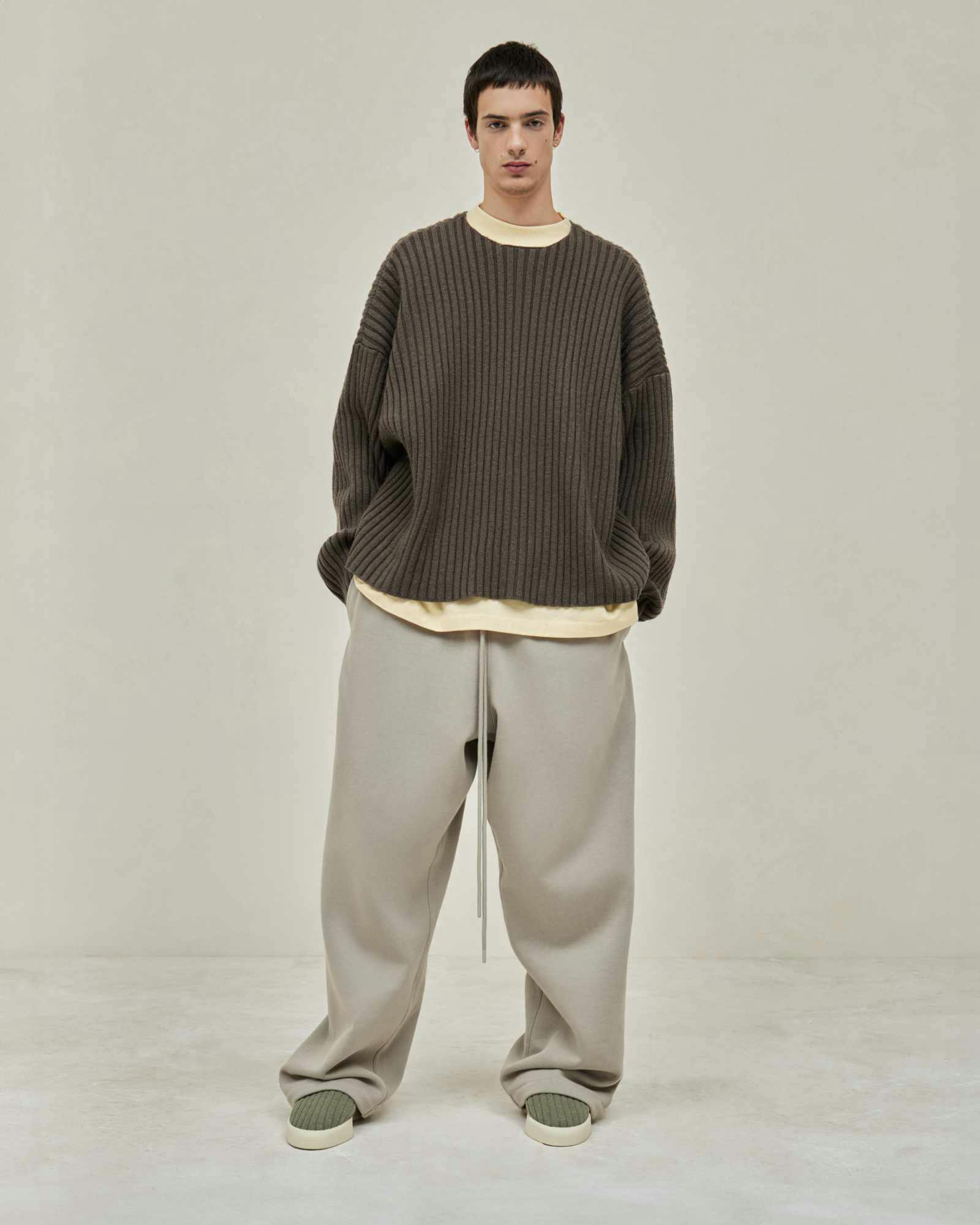 Models wear Fear of God ESSENTIALS' Winter 2023 hoodies, sweatshirts, t-shirts, and sweatpants