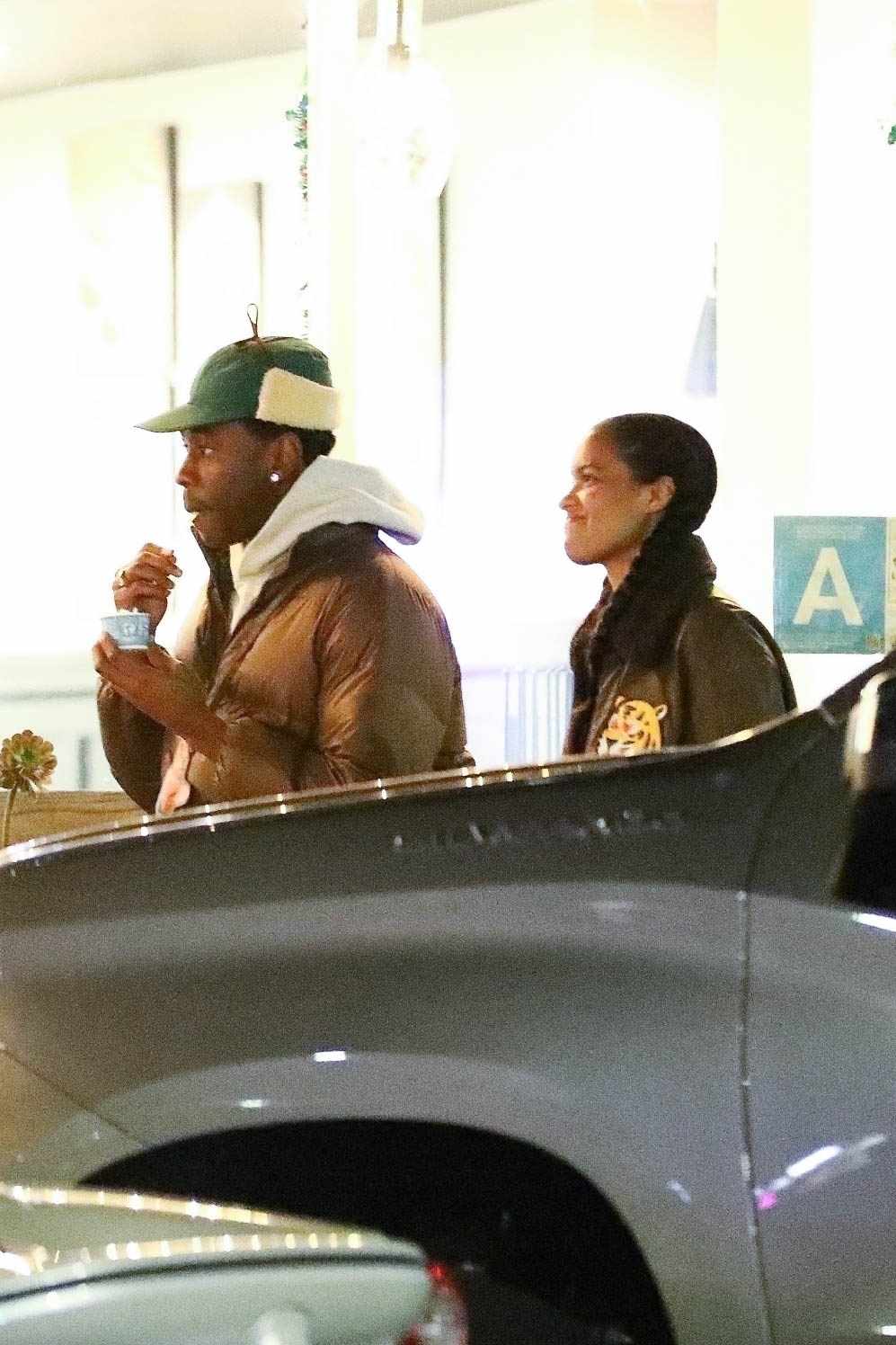 Tyler the Creator & a woman out on a date in December 2023, wearing a fur trapper hat and Louis Vuitton jacket