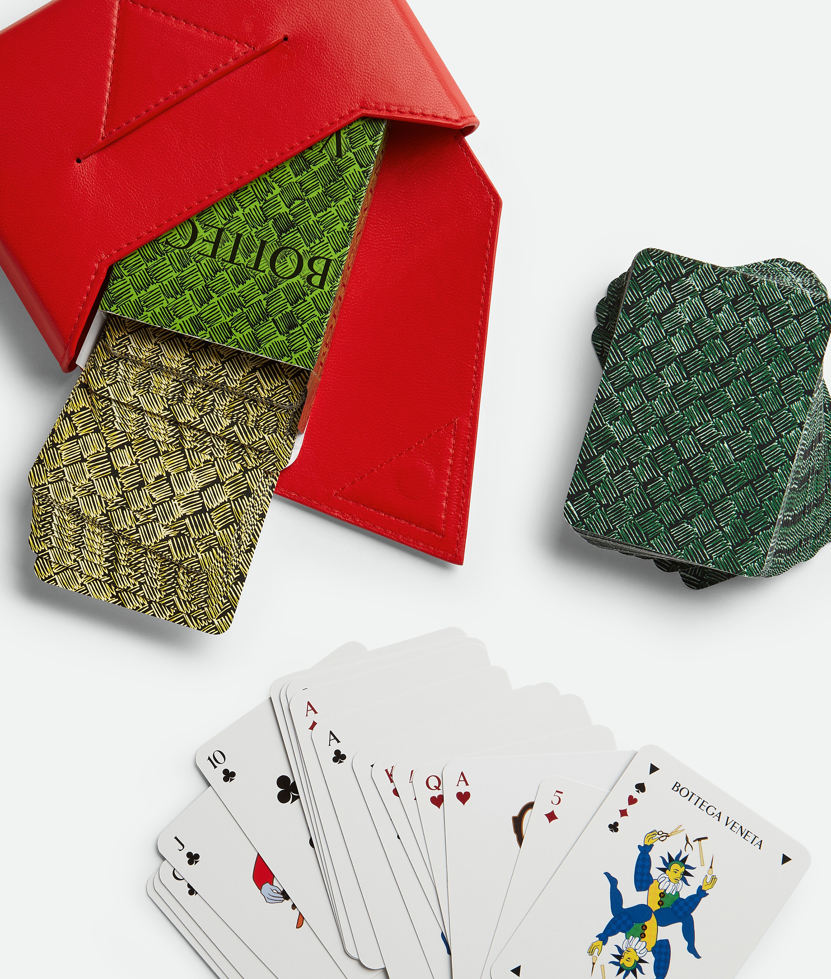 A set of Bottega Veneta playing cards with green backsides and a red case