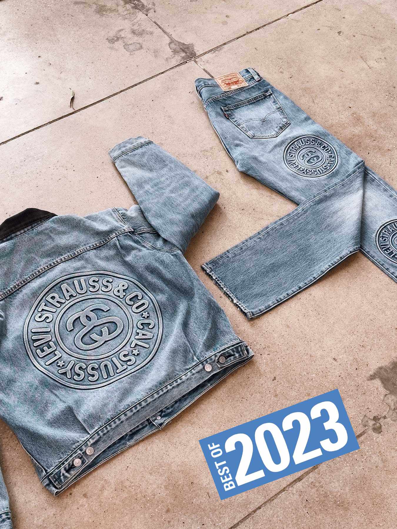 A Stussy x Levi's denim jacket & 501 jeans in light blue wash laying on the ground