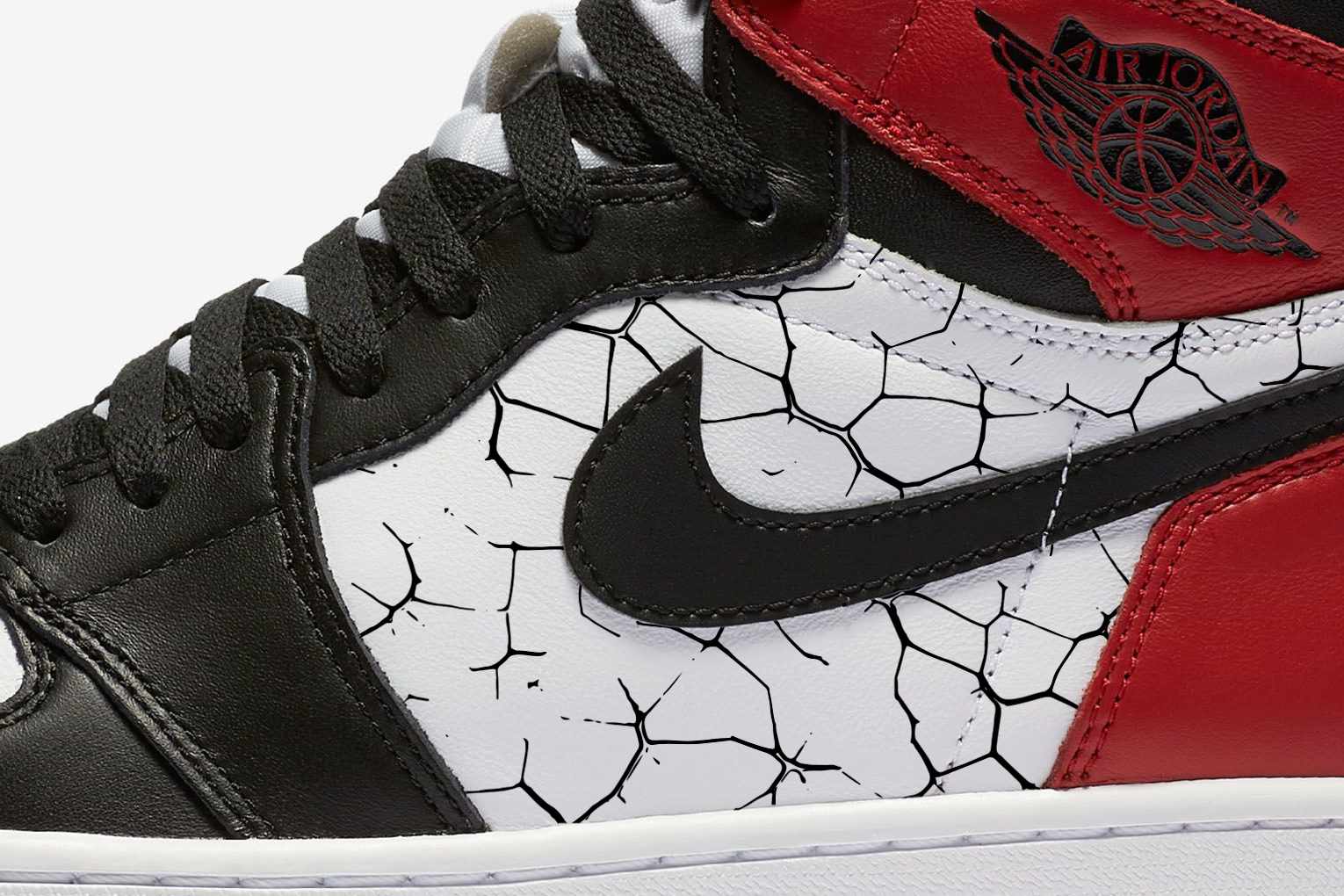 Nike's Air Jordan 1 Black Toe reimagined 2024 sneaker, with a white, red, and black distressed leather upper