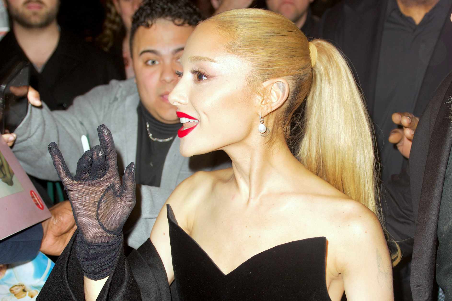 Ariana Grande wearing a black dress with matching gloves & red lipstick