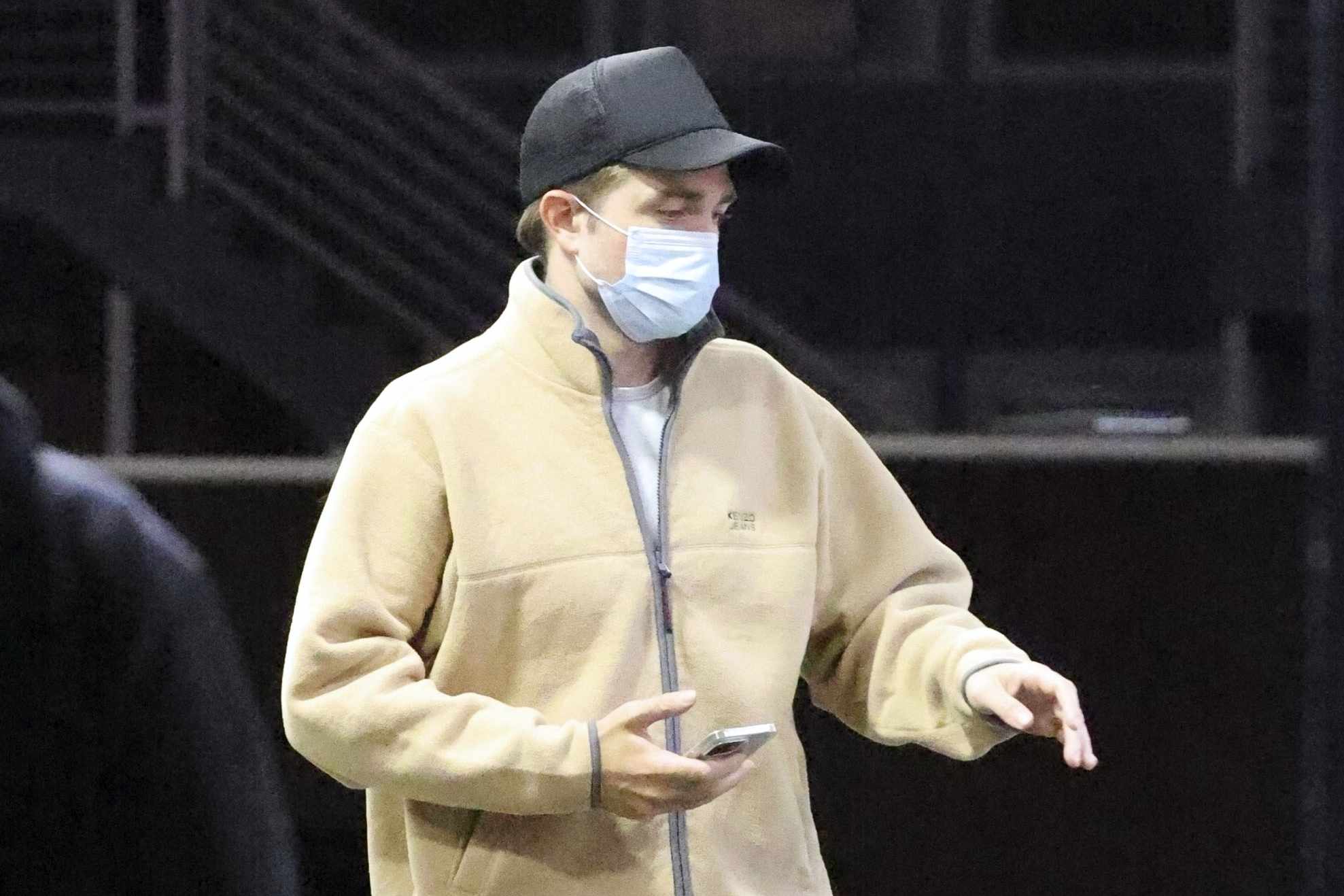 Robert Pattinson wears a beige Kenzo jeans fleece, shorts, and adidas sneakers