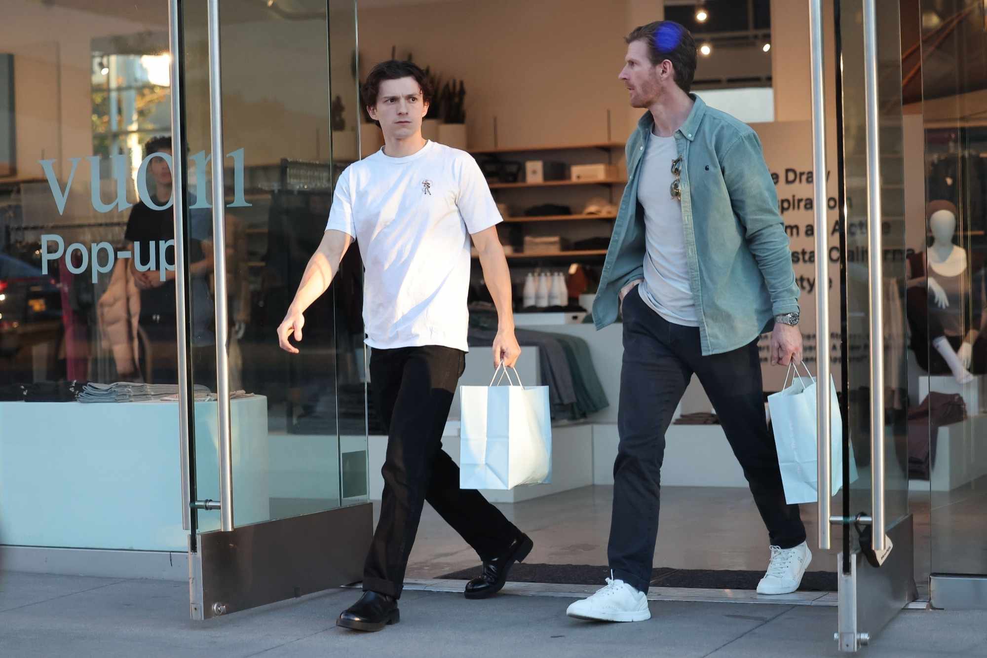 Tom Holland wears a white T-shirt and black pants with black leather shoes