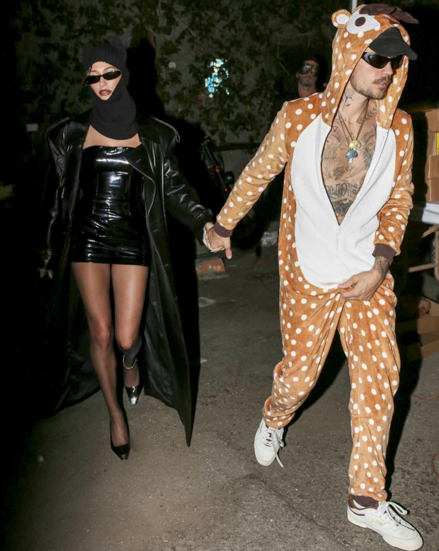 Justin & Hailey Bieber wear their 2023 Halloween costumes. Hailey is dressed in leather & Justin has a giraffe costume