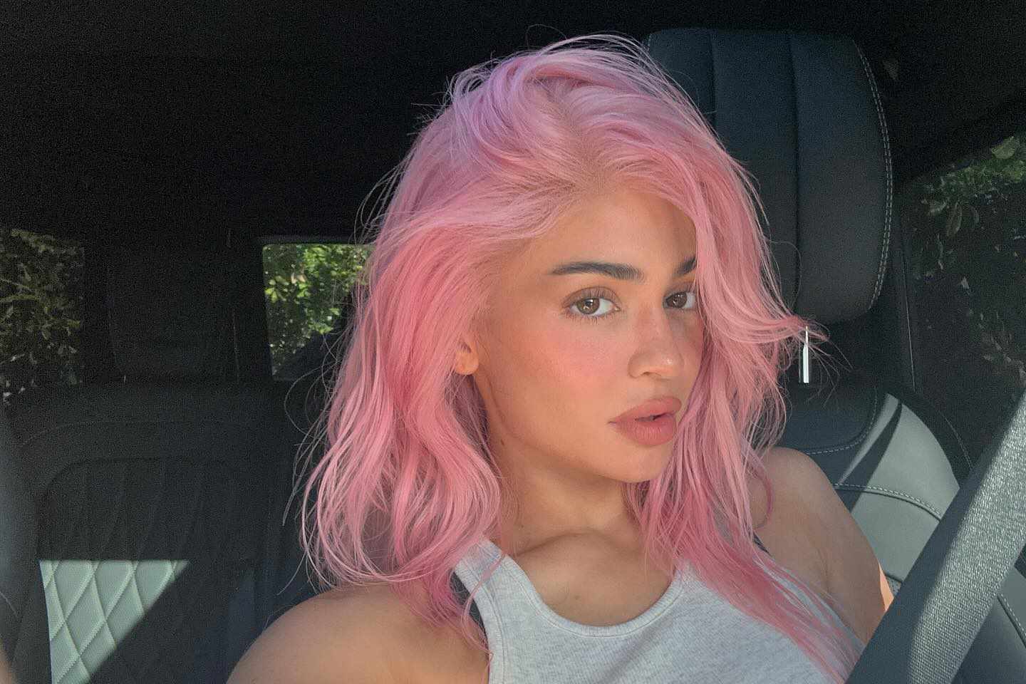 Kylie Jenner takes a selfie in a car with pink hair