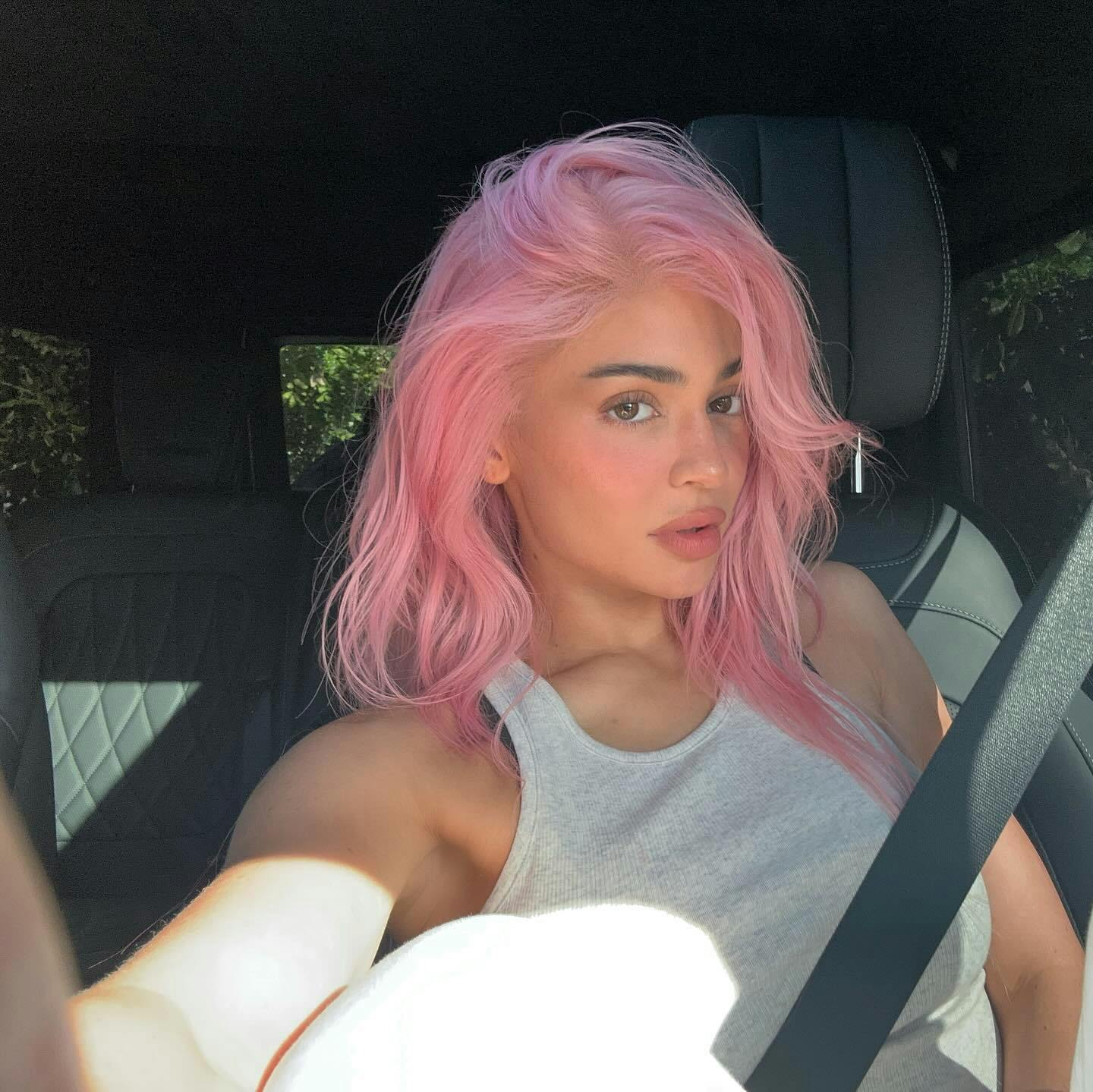 Kylie Jenner takes a selfie in a car with pink hair