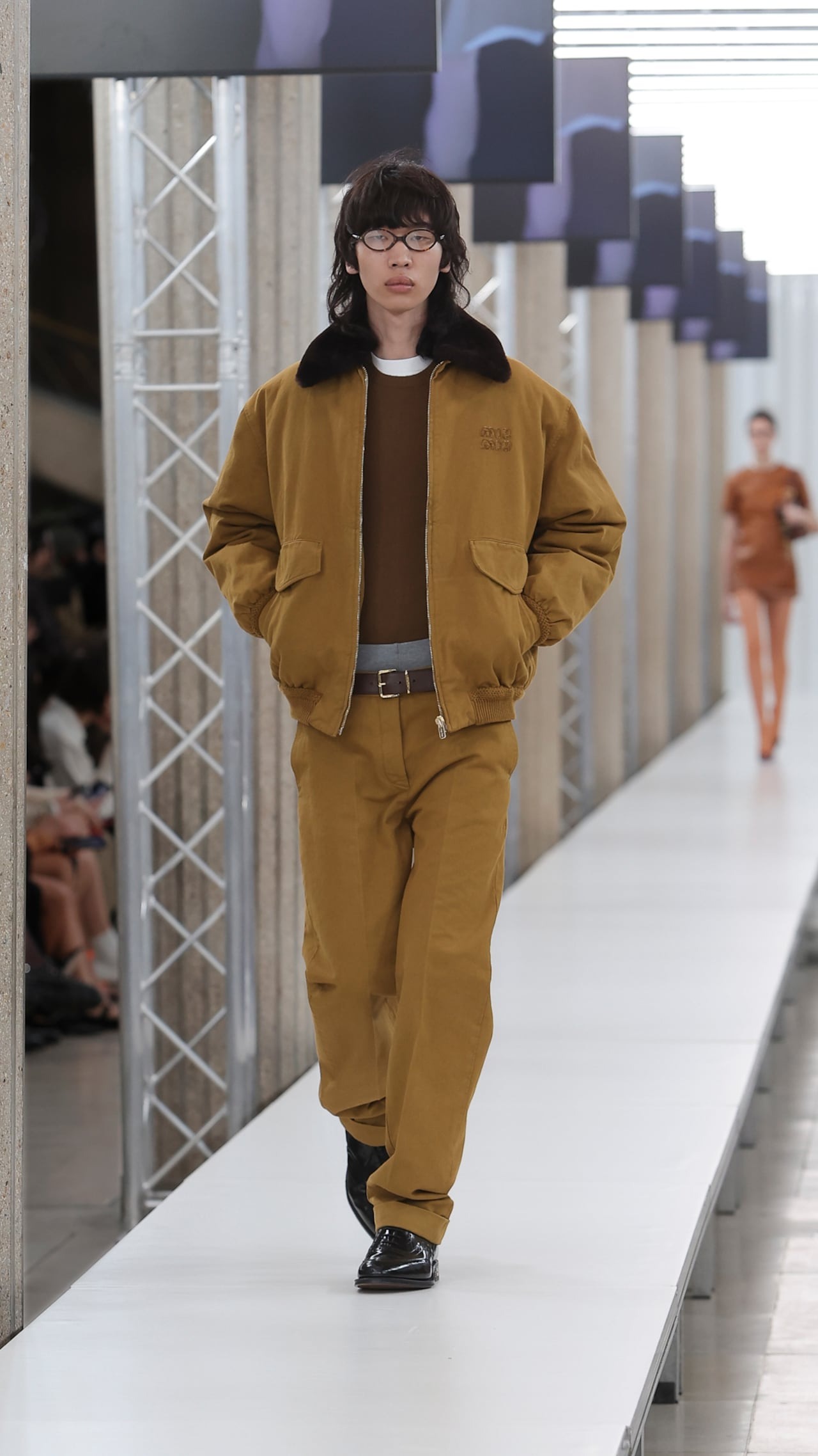 A model wears a Miu Miu menswear Carhartt-inspired jacket