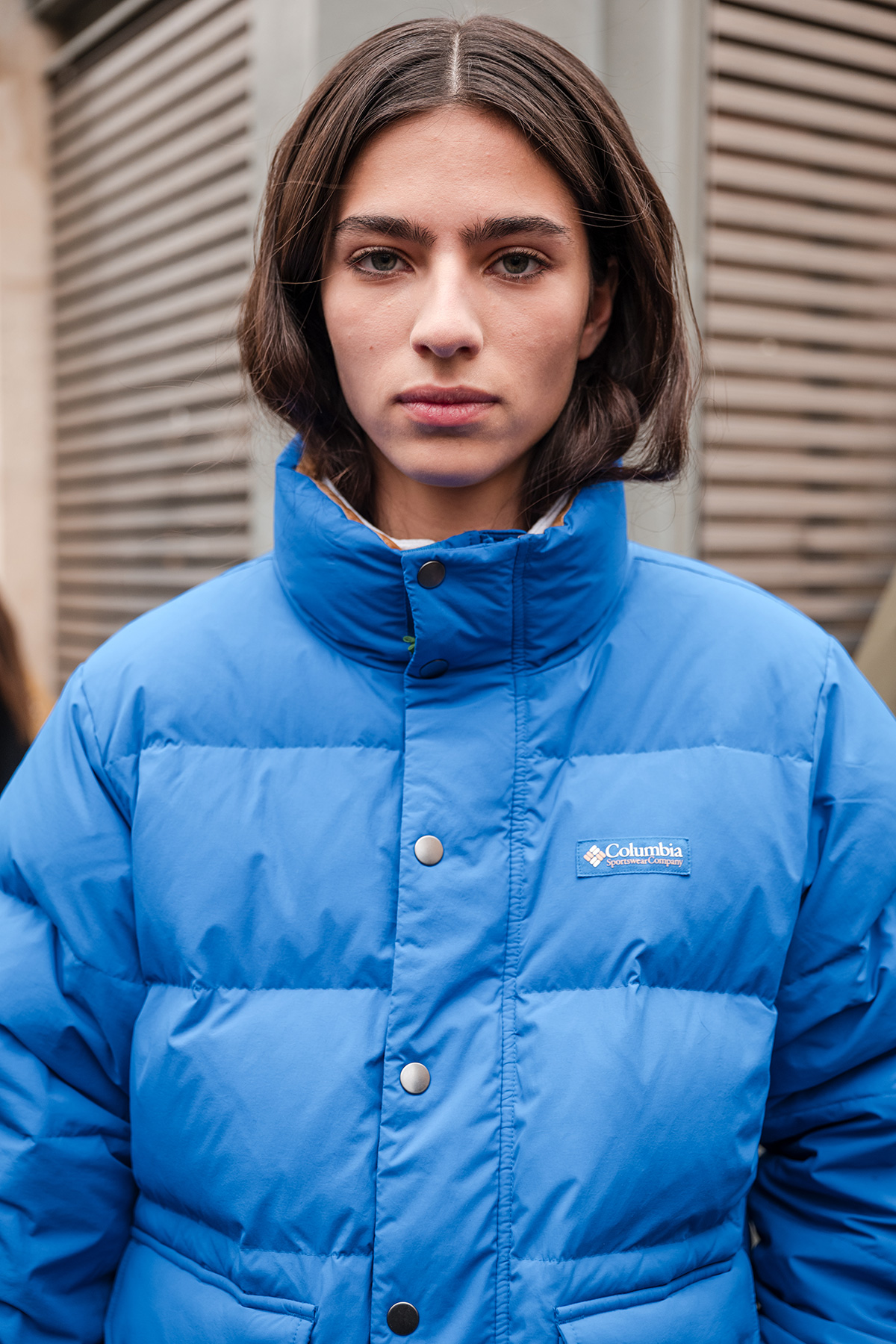 A guest wears blue Columbia puffed jacket, outside Sacai, during the Menswear Fall/Winter 2024/2025 as part of Paris Fashion Week on January 21, 2024 in Paris, France.