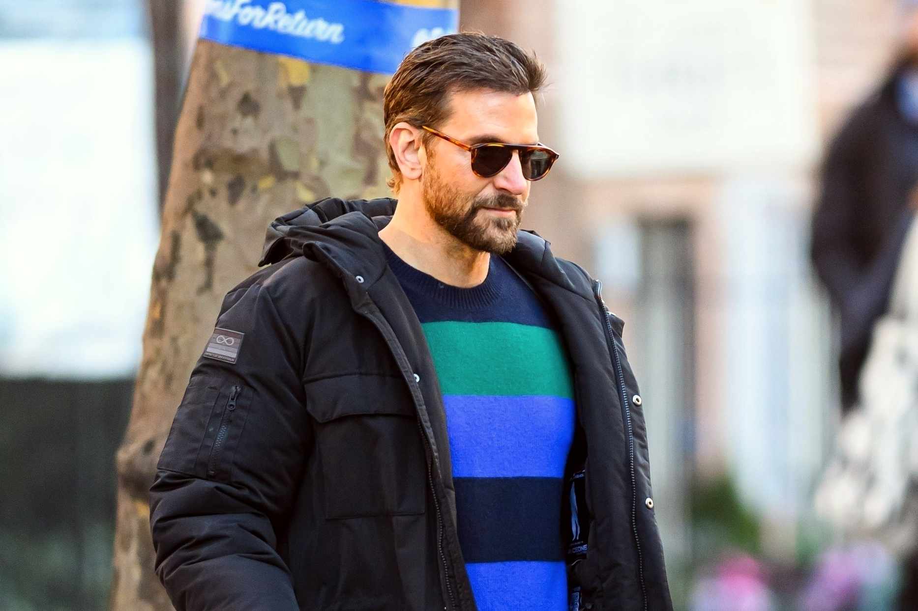 Bradley Cooper wears a Spaceone coat and striped sweater from Gigi Hadid's brand with Salomon sneaker boots