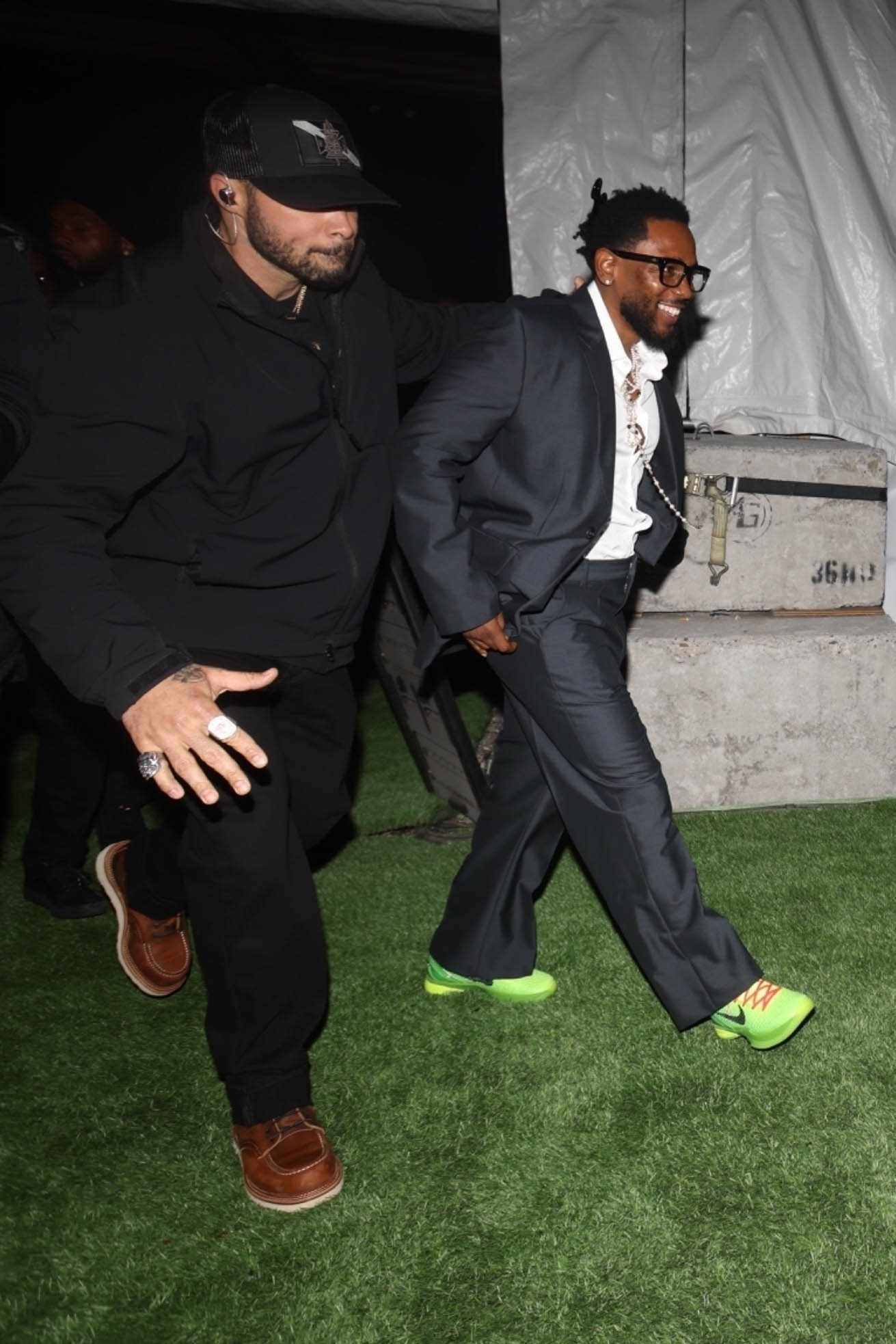 Kendrick Lamar wears a black suit, white shirt, and yellow sneakers at Cash App's Super Bowl 2024 party