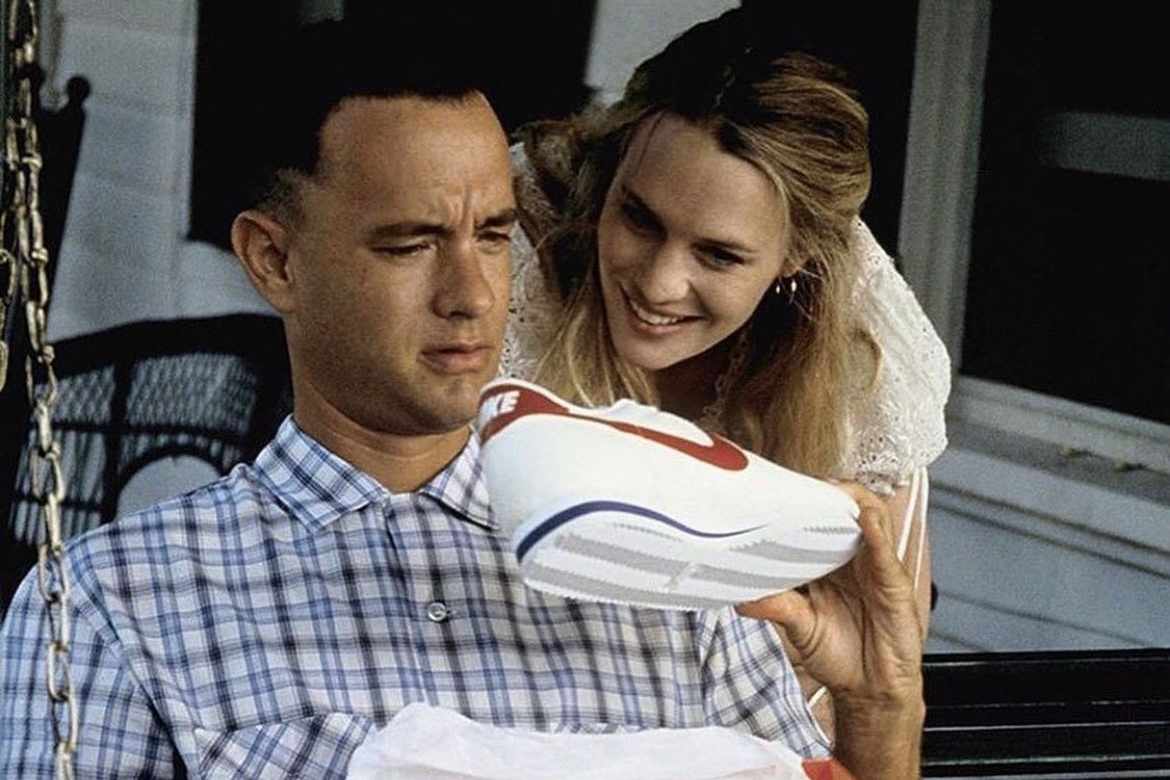 Tom Hanks' Forrest Gump holds a pair of Nike Cortez sneakers in white, red, and blue