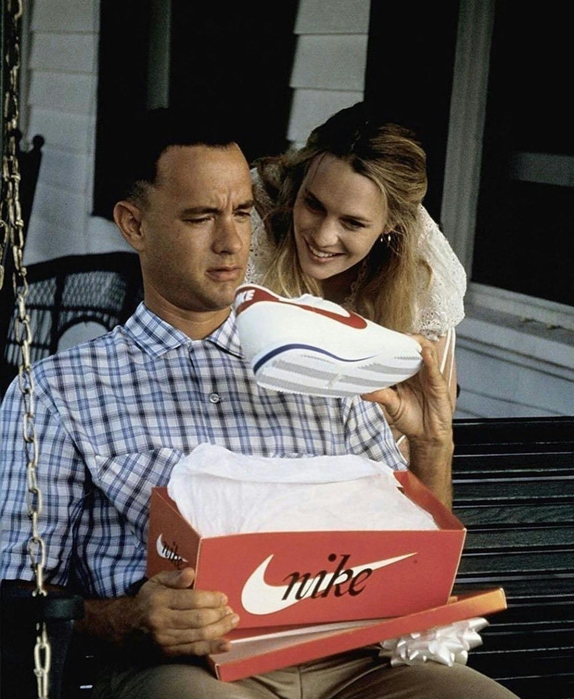 Tom Hanks' Forrest Gump holds a pair of Nike Cortez sneakers in white, red, and blue