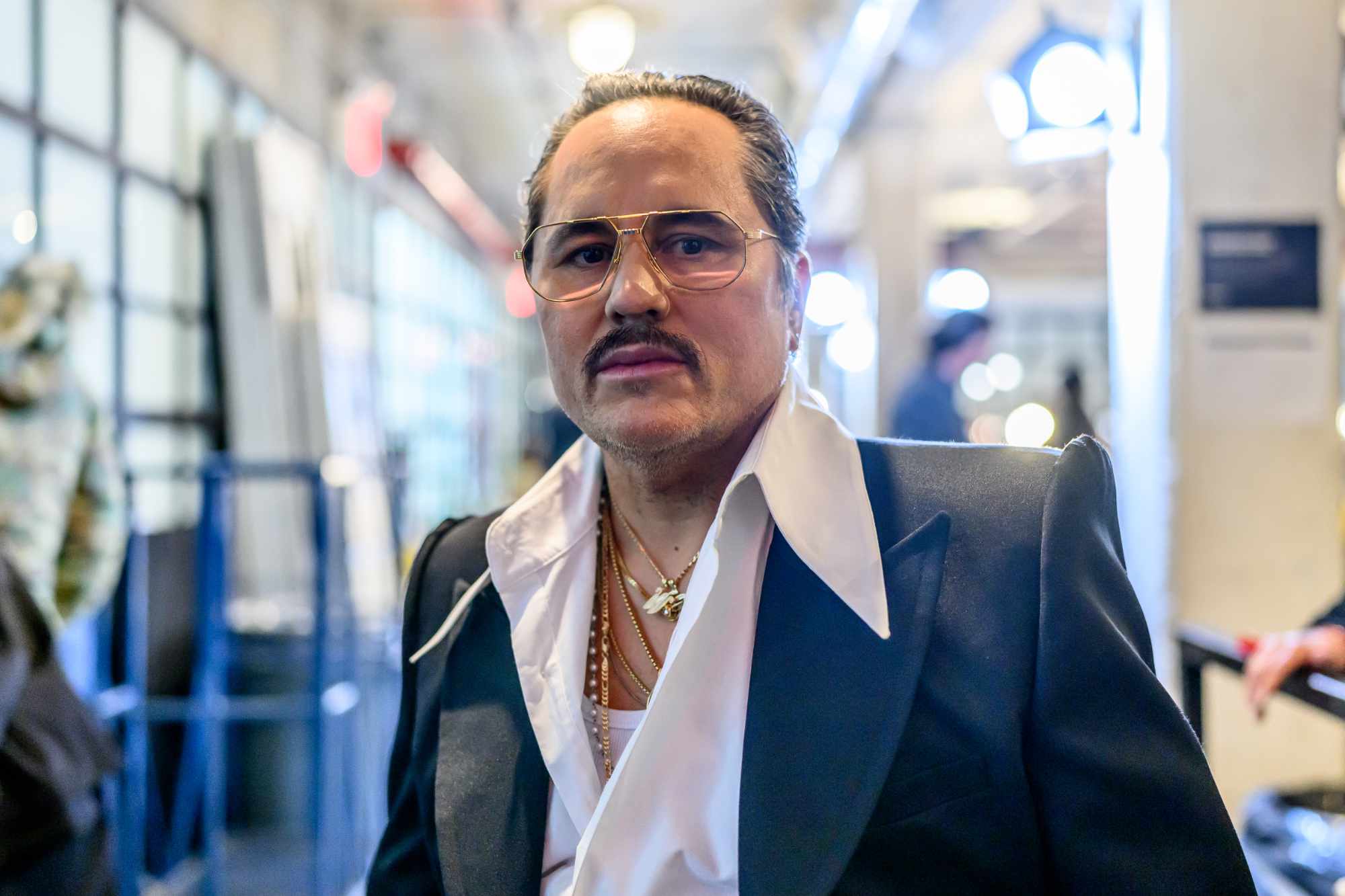 Designer Willy Chavarria, seen wearing a blue jacket and white shirt backstage