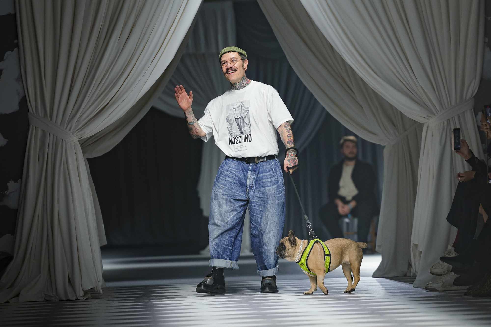 Moschino creative director Adrian Appiolaza wears a white t-shirt and blue jeans with his pug