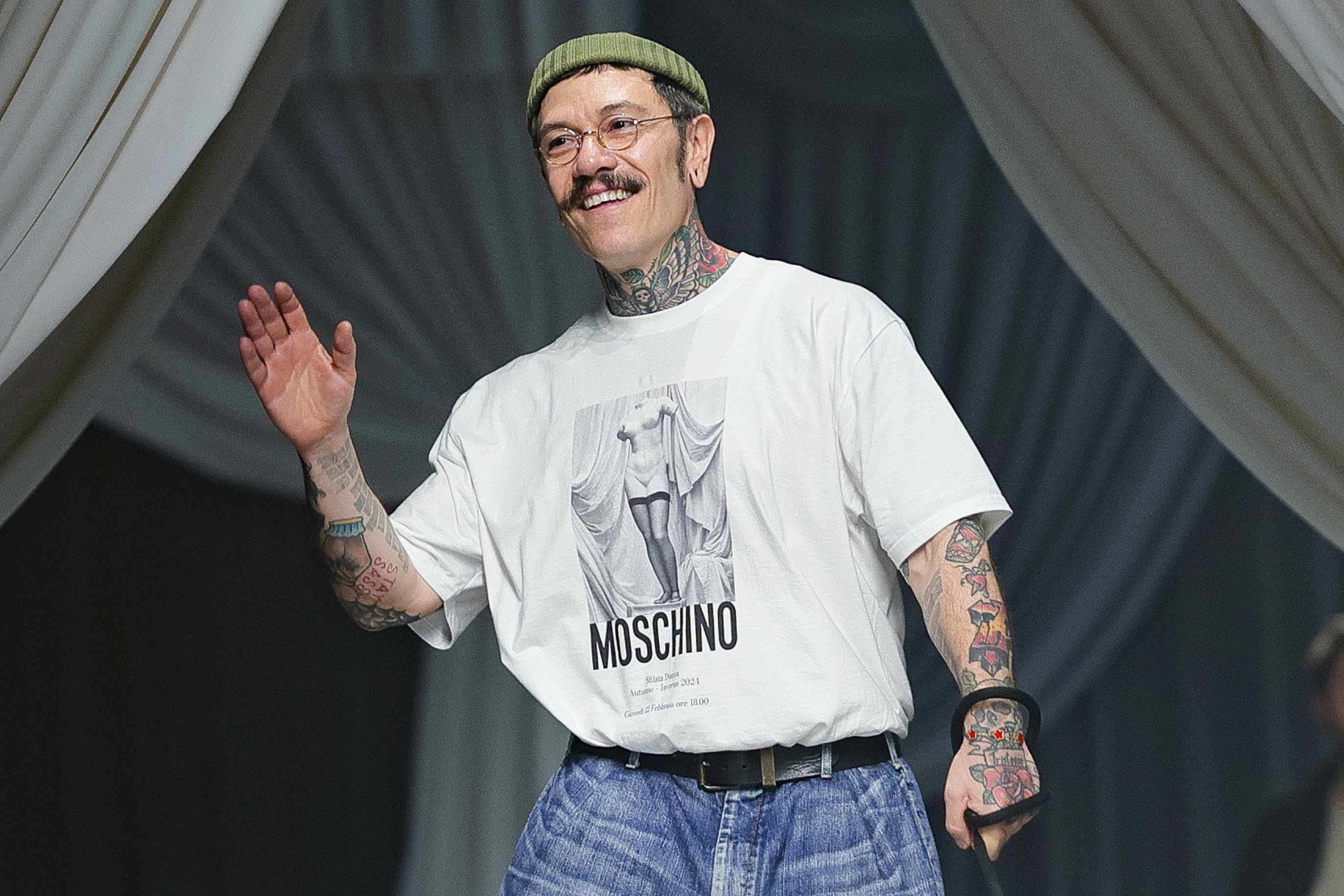 Moschino creative director Adrian Appiolaza wears a white t-shirt and blue jeans with his pug