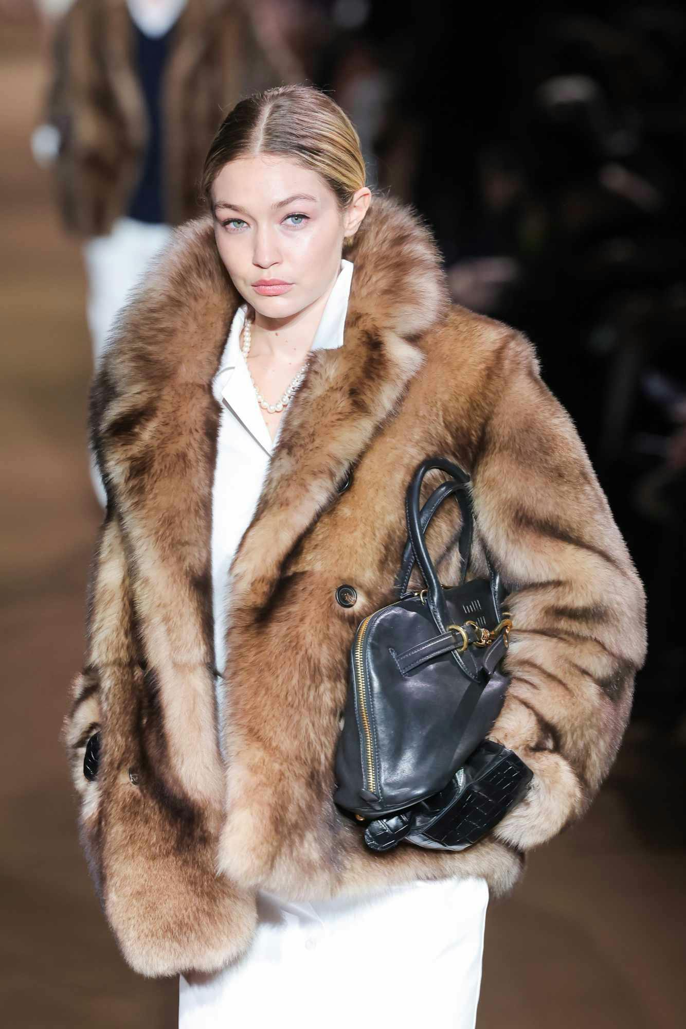 Gigi Hadid wearing a fur coat at the Miu Miu FW24 runway show