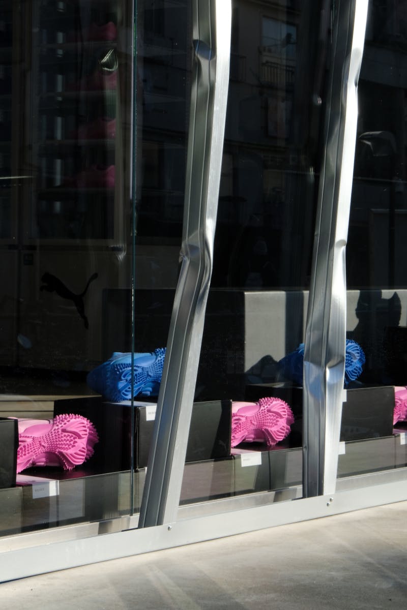 Window display of blue and pink PUMA shoes