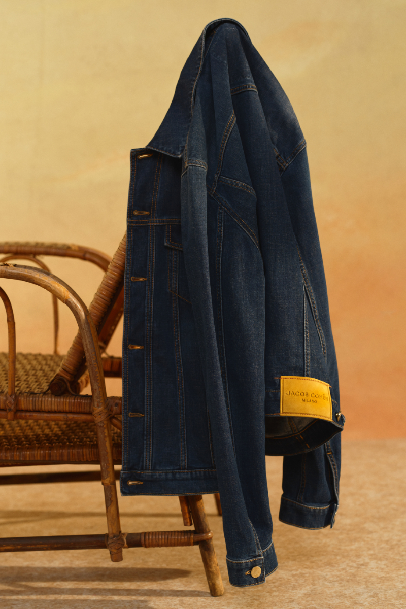 Denim jacket hanging off the back of a wicker chair