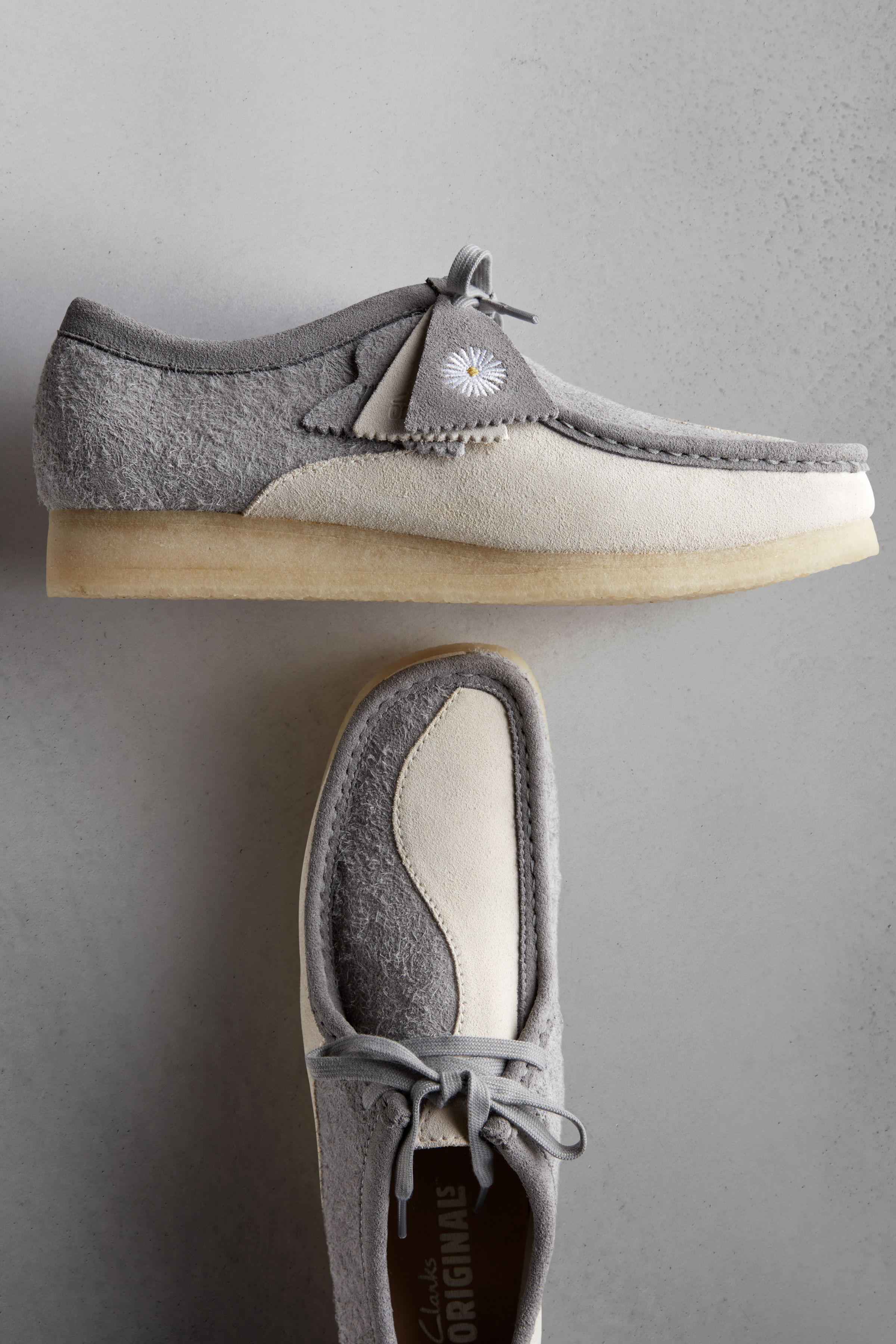 One suede moccasin shoe sits on top of the other