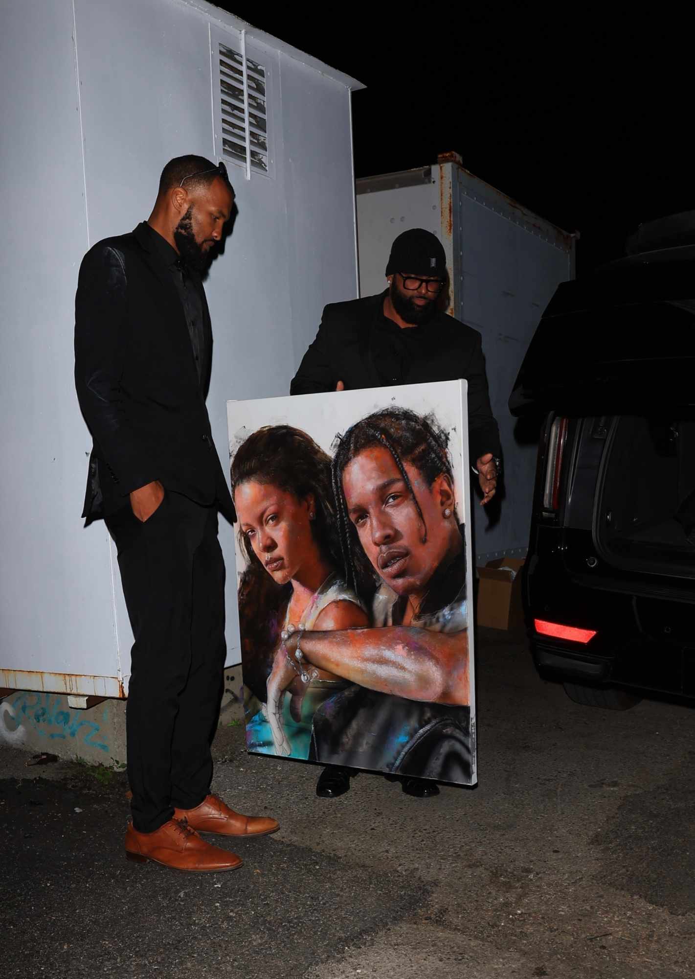 A Rihanna & A$AP Rocky painting held by Rihanna's bodyguards
