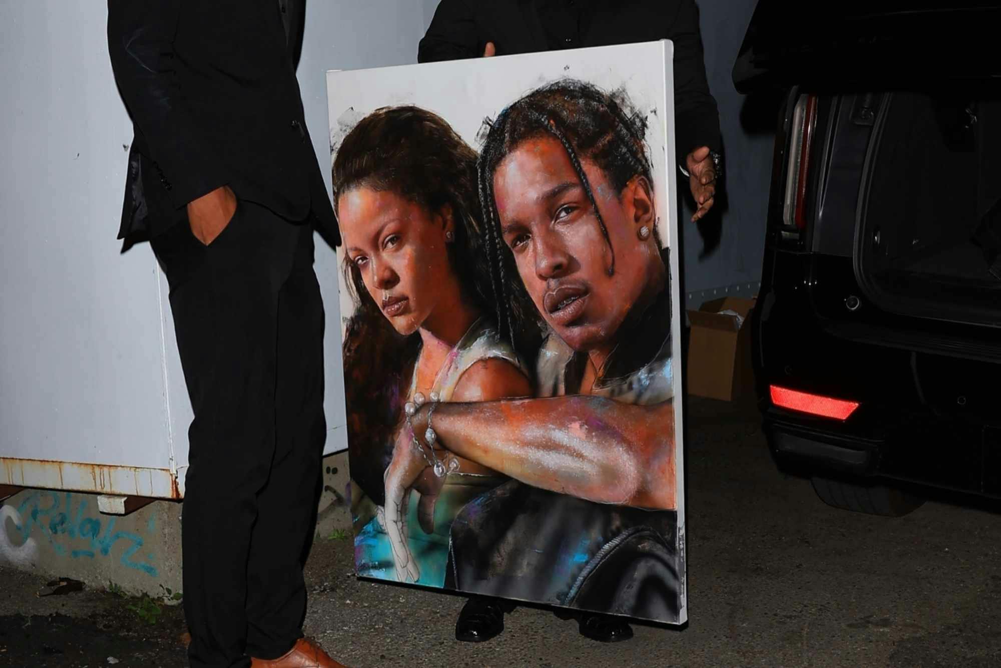 A Rihanna & A$AP Rocky painting held by Rihanna's bodyguards