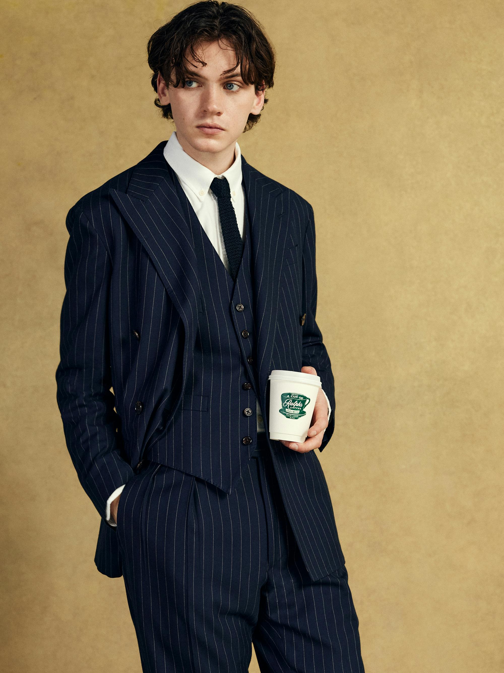 Model stands wearing a Ralph Lauren pinstripe suit