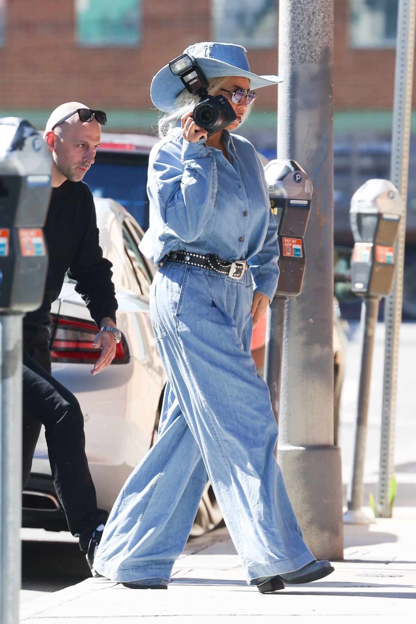 Beyonce wears a blue denim suit, cowboy hat and grey boots with a black belt