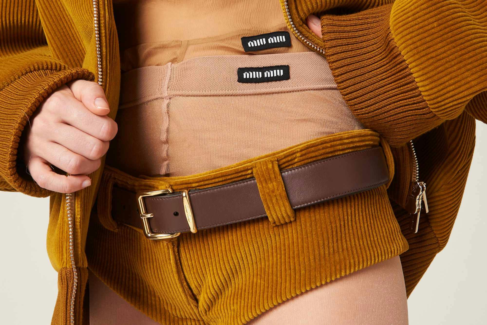 A model wears Miu Miu's brown corduroy shorts with exposed underwear