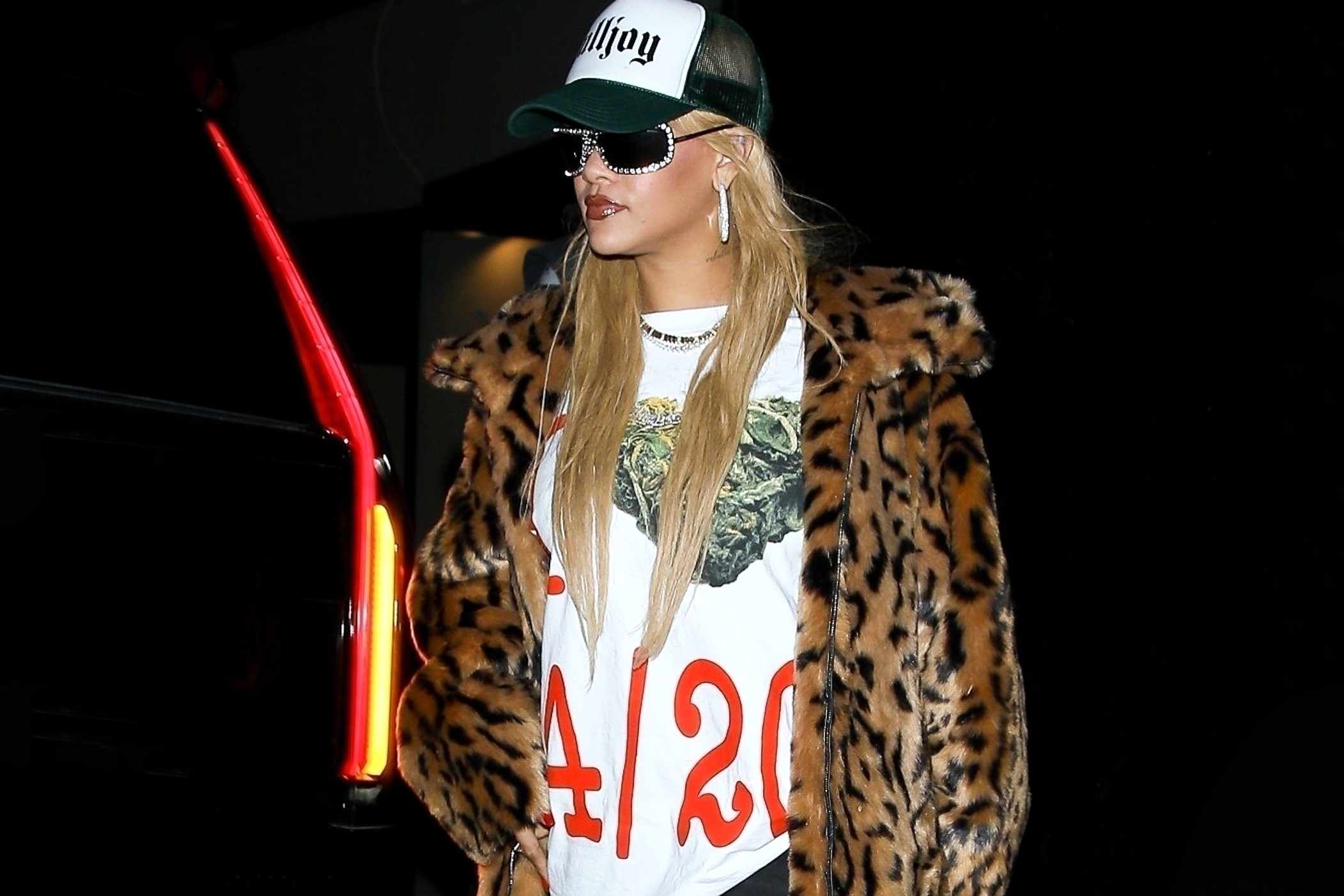 Rihanna wears a 420 weed T-shirt, leopard-printed fur coat, and white killjoy hat with giant diamond-studded sunglasses in Los Angeles