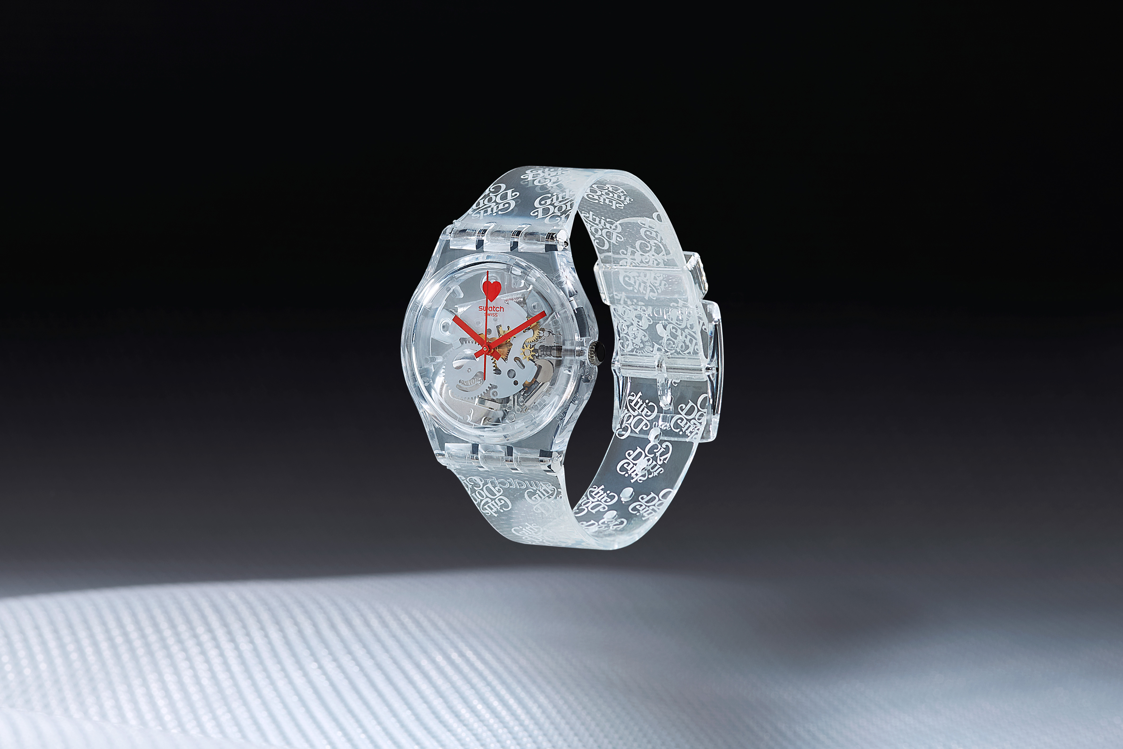 A transparent watch with red hands against a spacey background