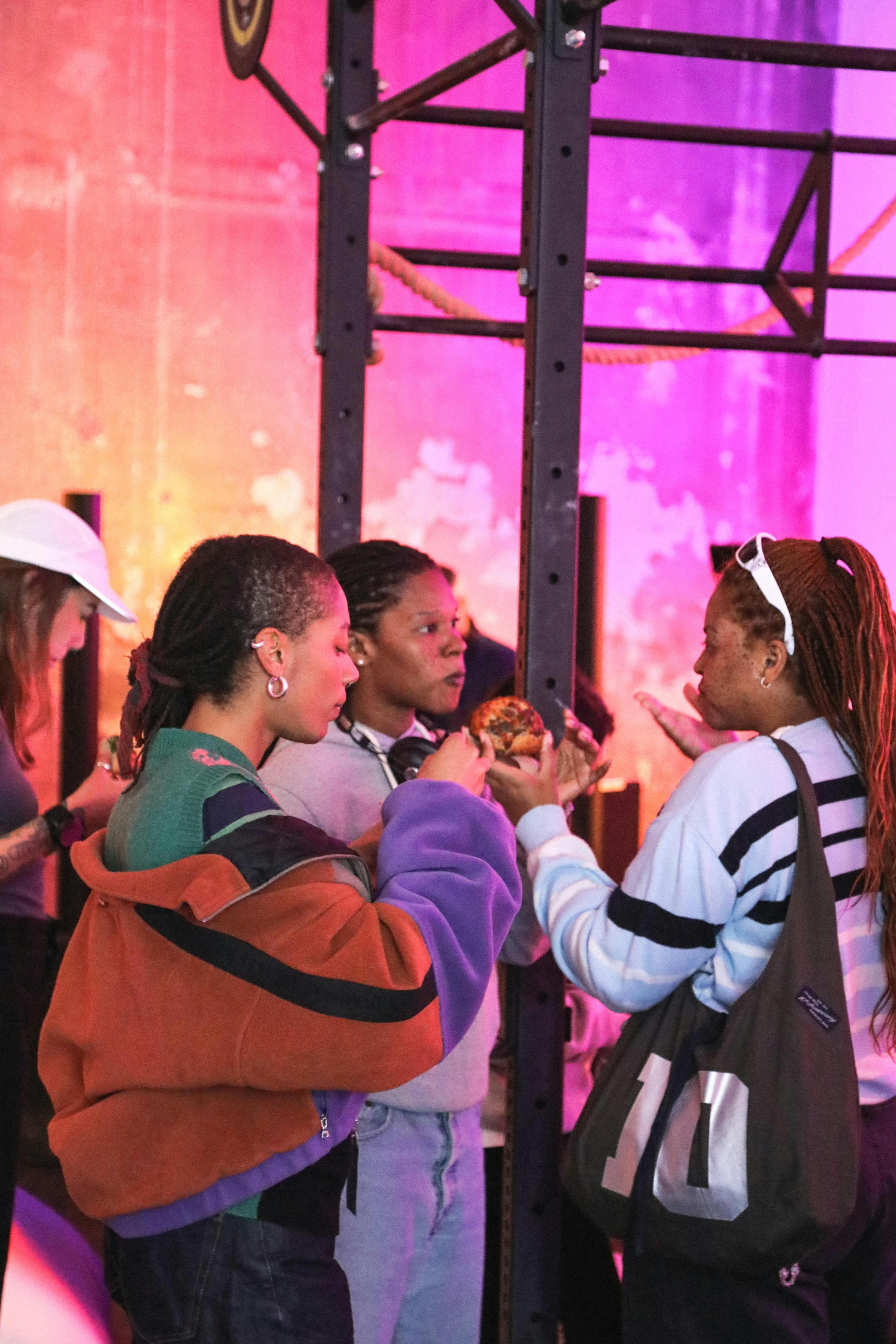 Three people having drinks and conversing at a sports brand's event