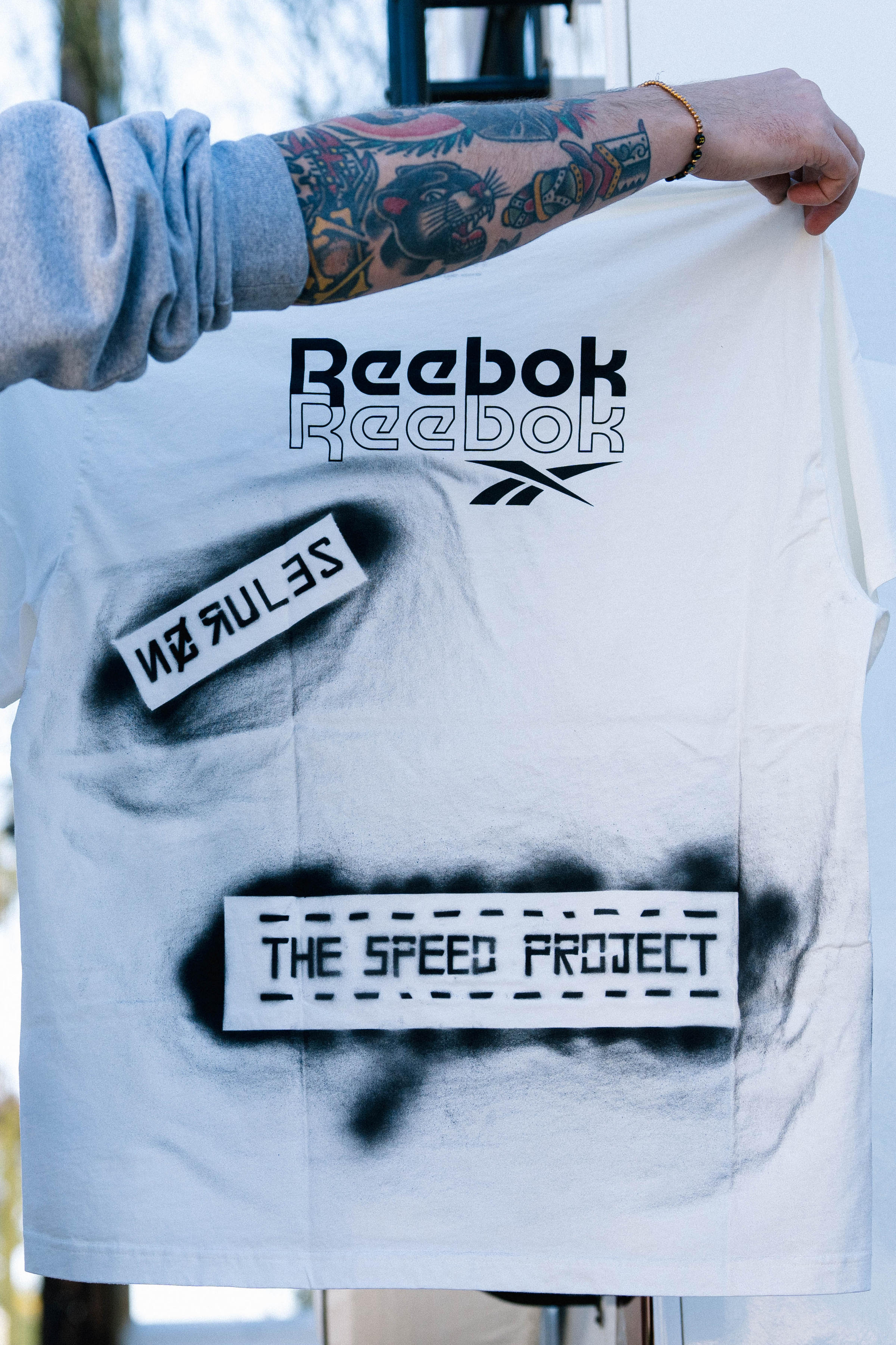 T-shirt spray painted 'Reebok' and 'Speed Project'
