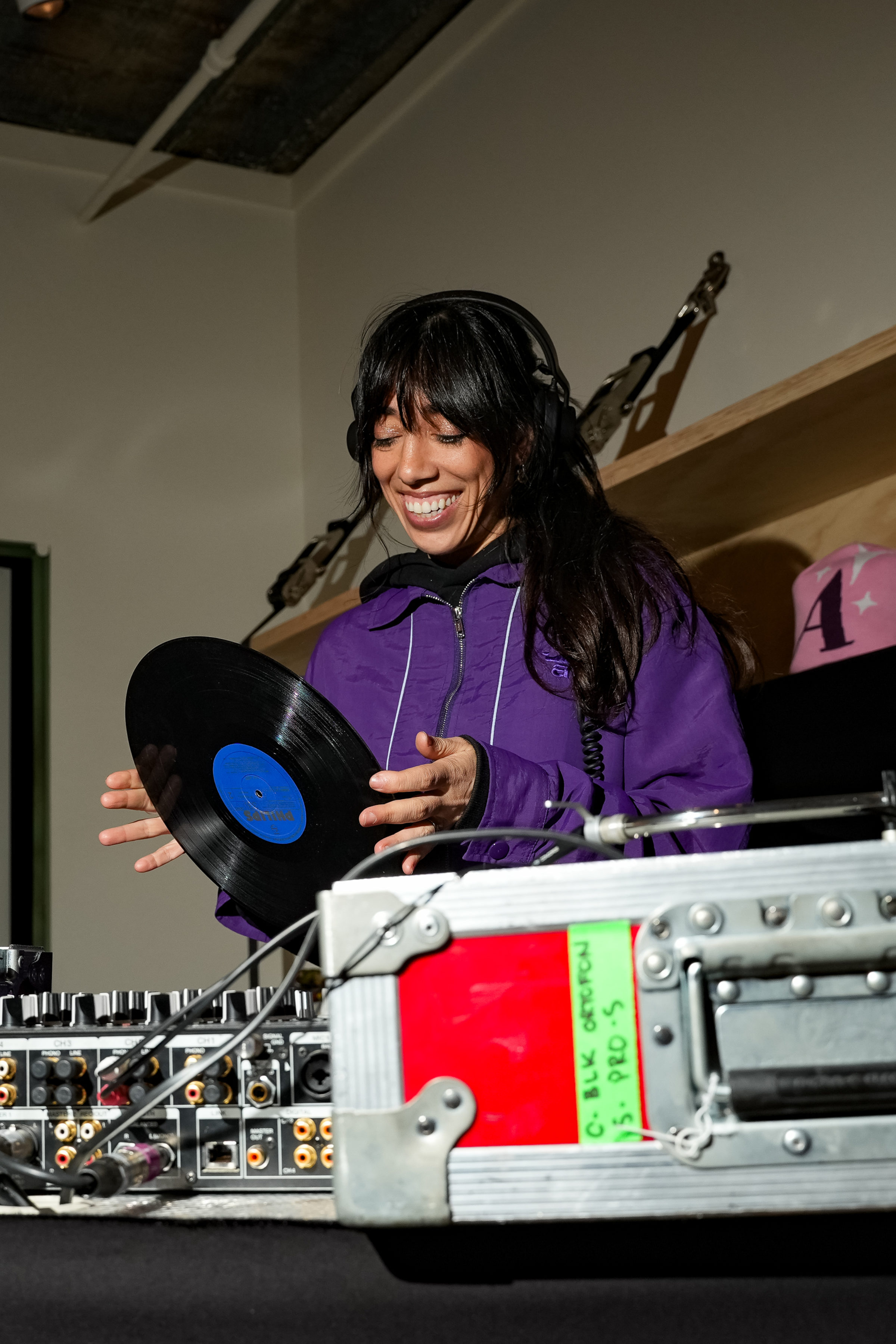A woman behind the decks changing the record at a live event
