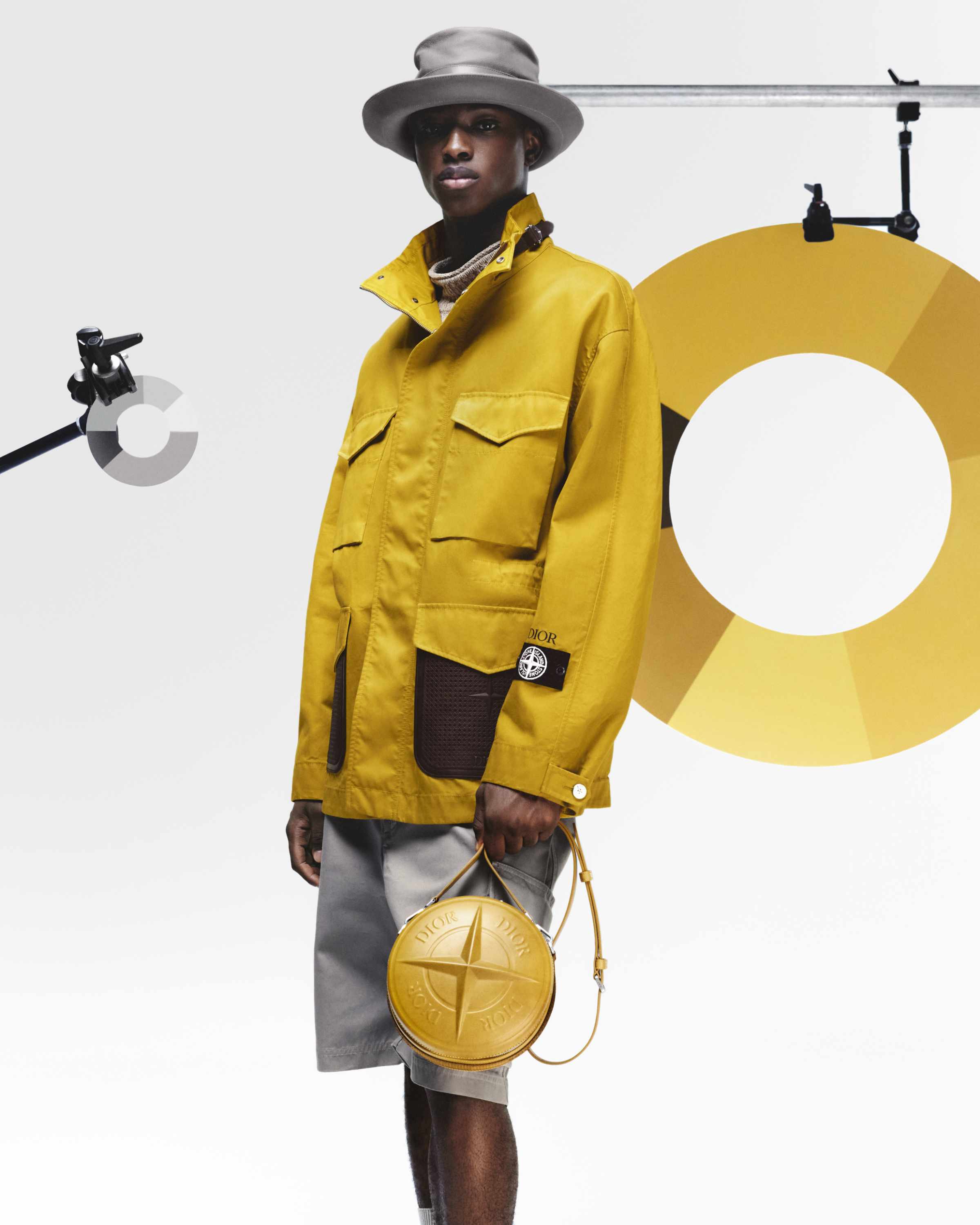 Dior x Stone Island yellow hat, yellow jacket, and yellow shorts with black compass rose badge logo