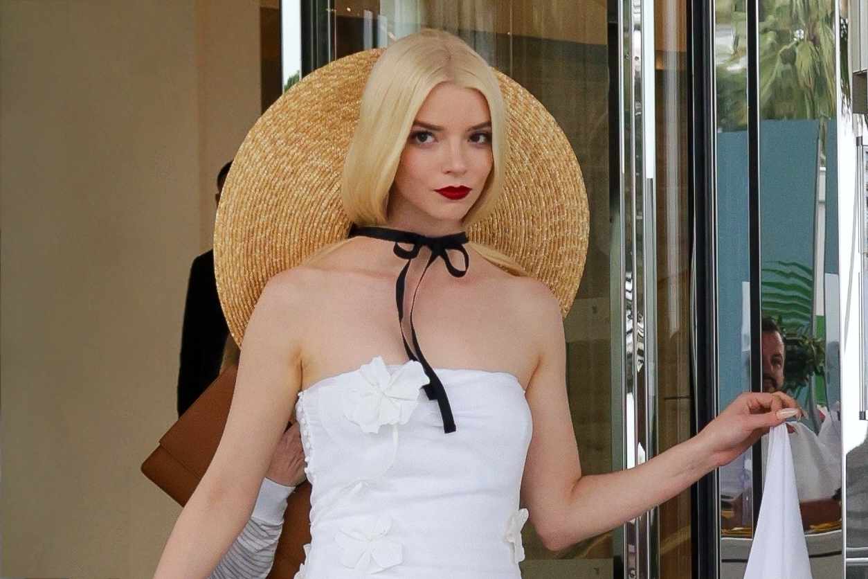 Anya Taylor Joy in a white Jacquemus dress and straw sun hat