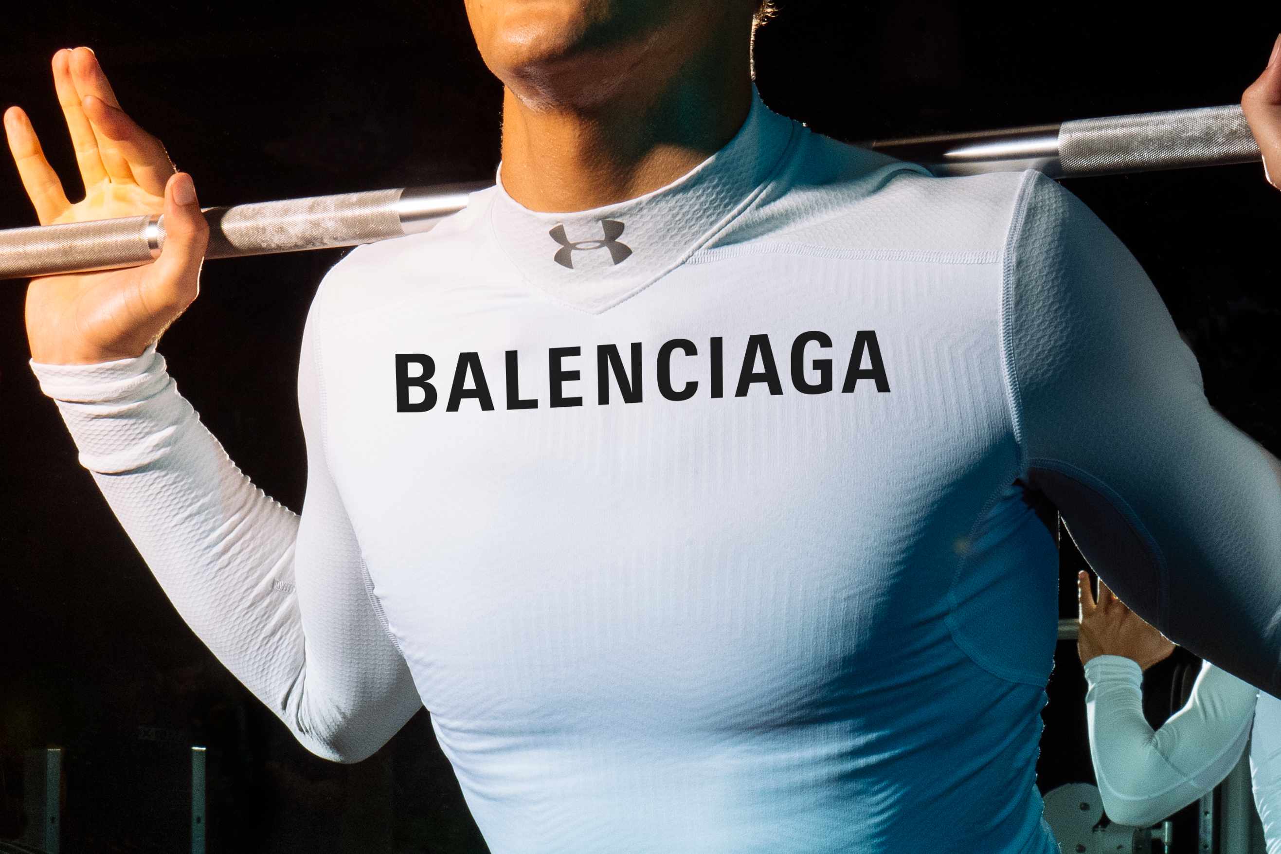 A weightlifter wears a shirt printed with Under Armour and Balenciaga logos
