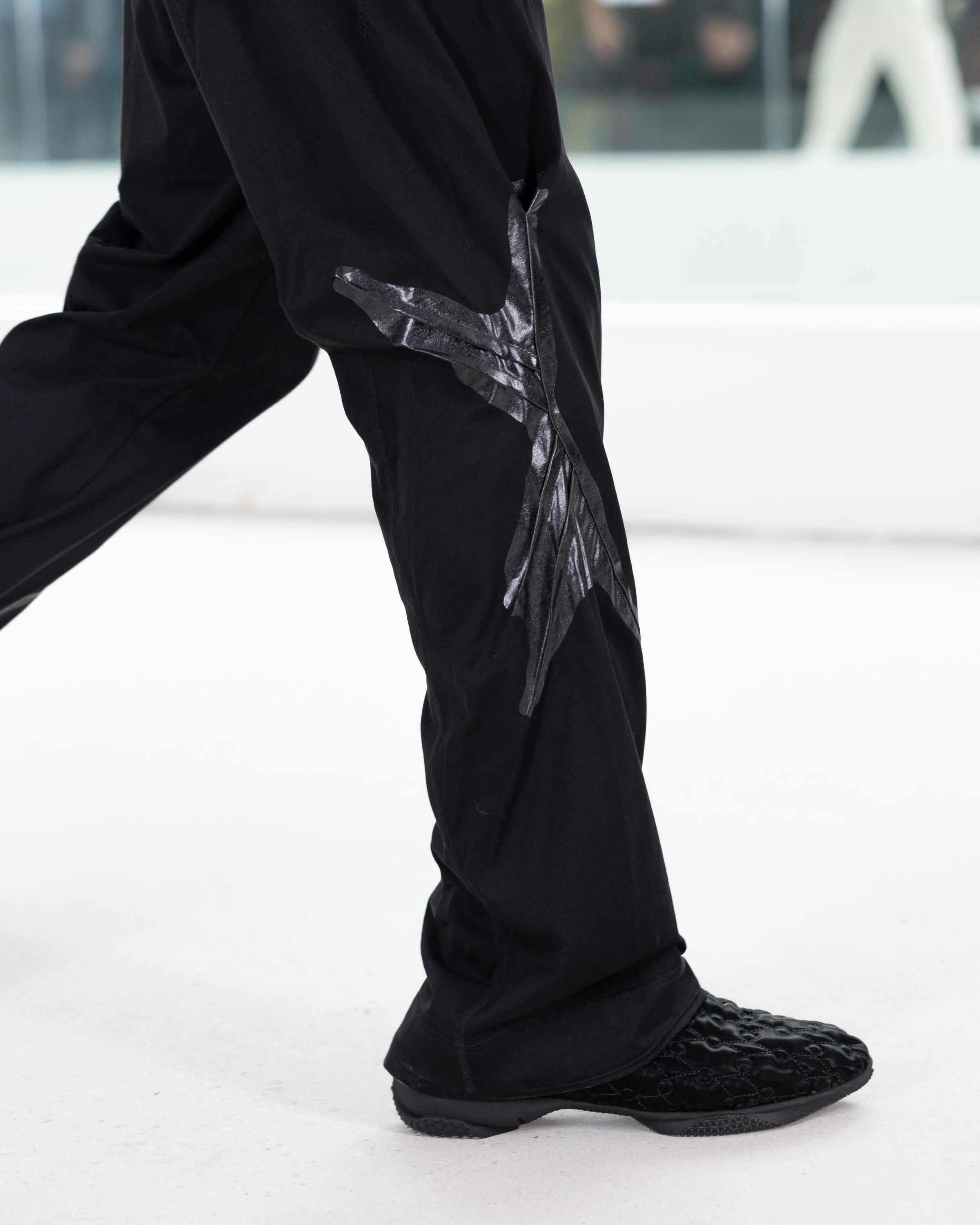 Models wear Kiko Kostadinov's SS25 menswear clothes, dark hats, shirts, pants, and shoes